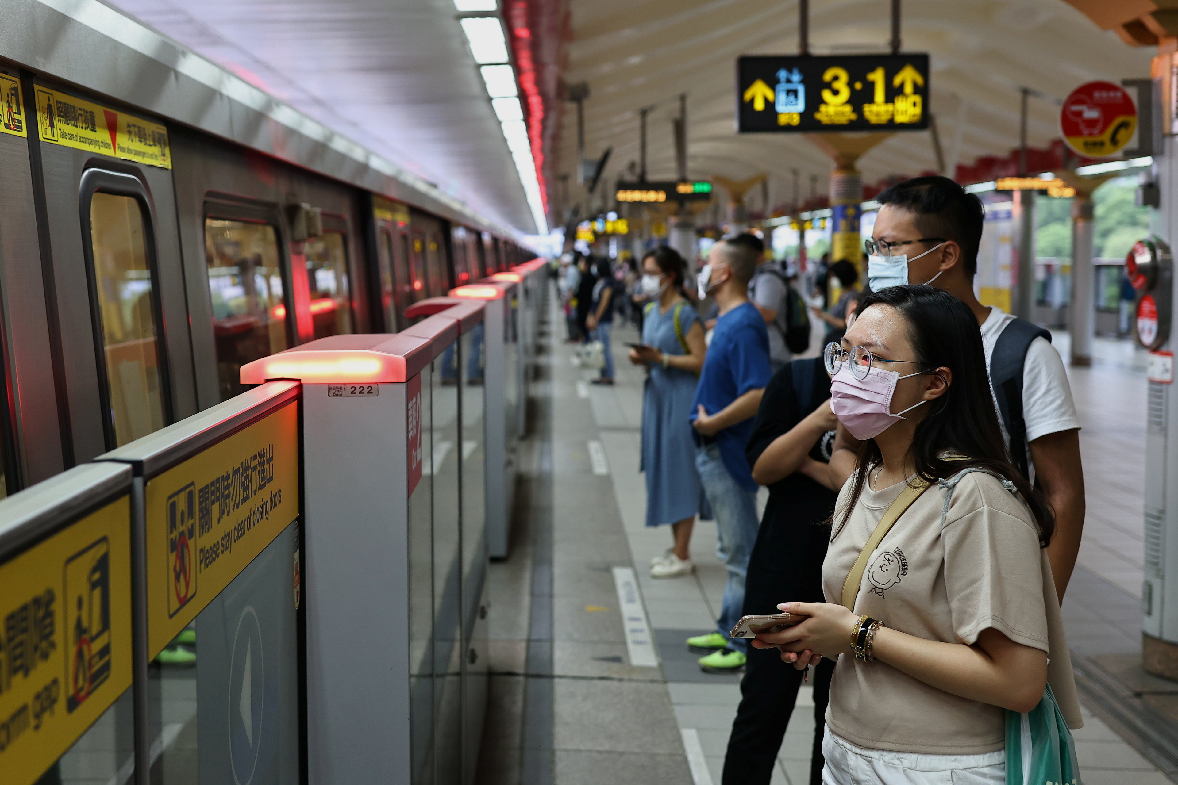 People wearing protective face masks wait for the metro, during the coronavirus disease (COVID-19) pandemic, in Taipei