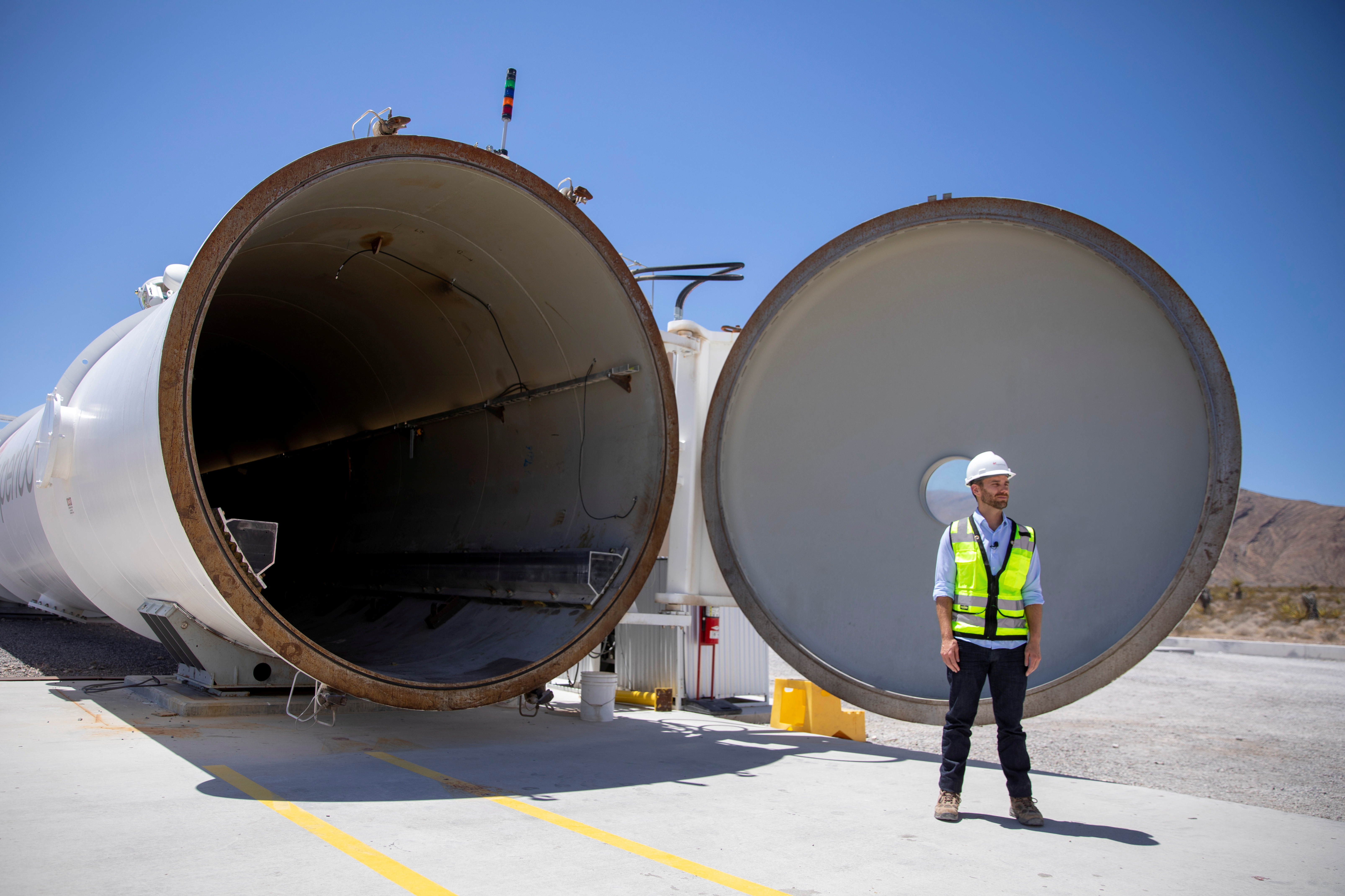 Josh Giegel, co-founder and CEO of Virgin Hyperloop, stands next to a hyperloop tube at the company's hyperloop facility near Las Vegas