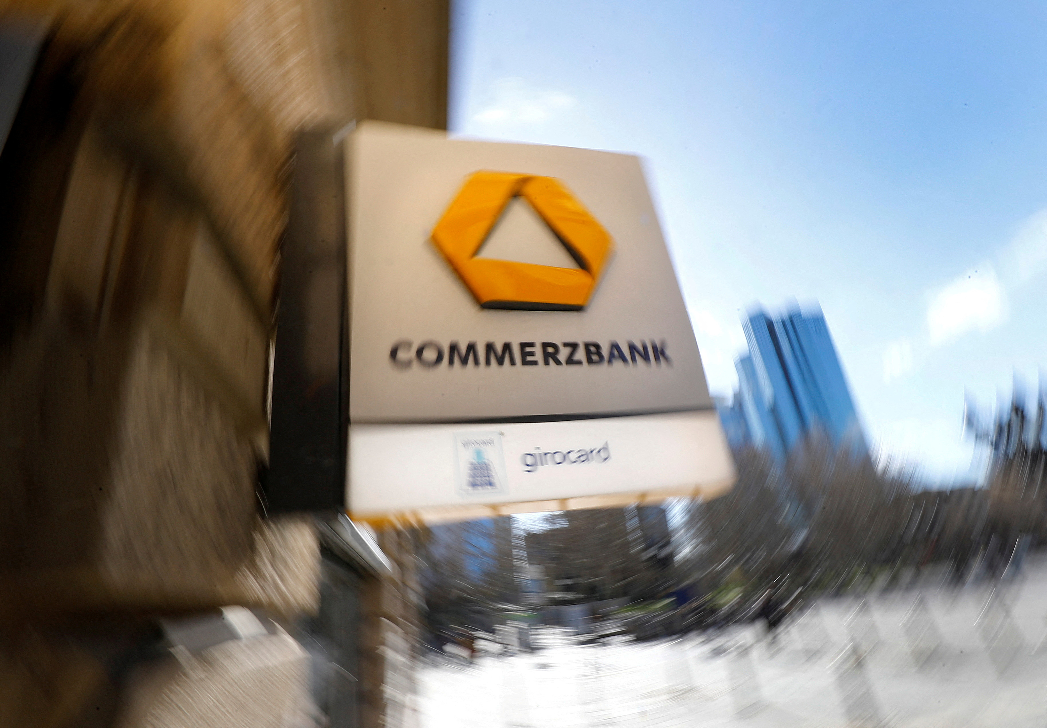 A sign for an ATM of Commerzbank is seen next to the headquarters of Deutsche Bank (R) in Frankfurt