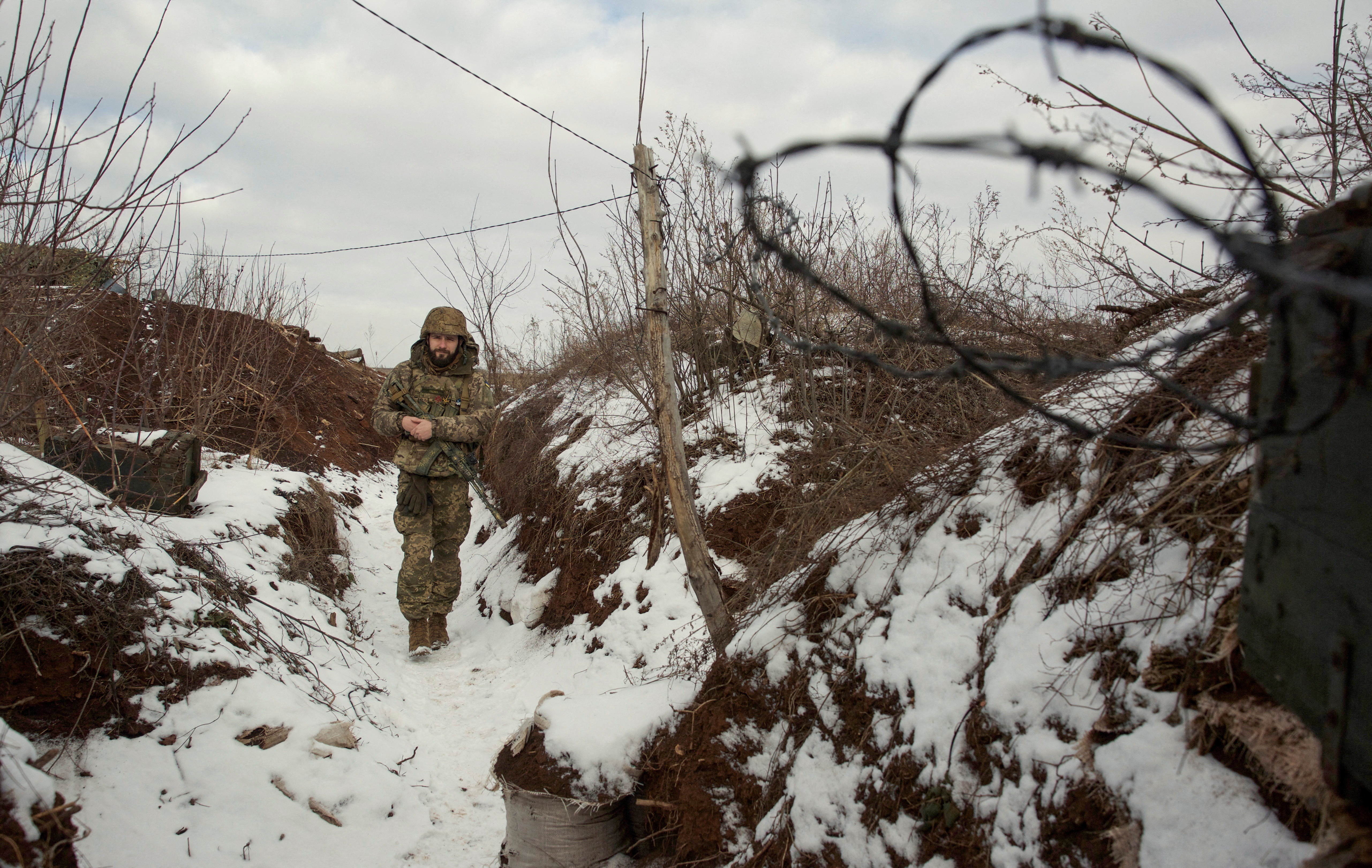 Një pjesëtar i shërbimit të forcave të armatosura të Ukrainës ecën në pozicionet luftarake pranë vijës së ndarjes nga rebelët e mbështetur nga Rusia pranë Horlivka në rajonin e Donetsk, Ukrainë, 22 janar 2022. Fotografia e marrë më 22 janar 2022. Fotografia e marrë REUTERS/Anna Kudriavtseva/ Foto e dosjes
