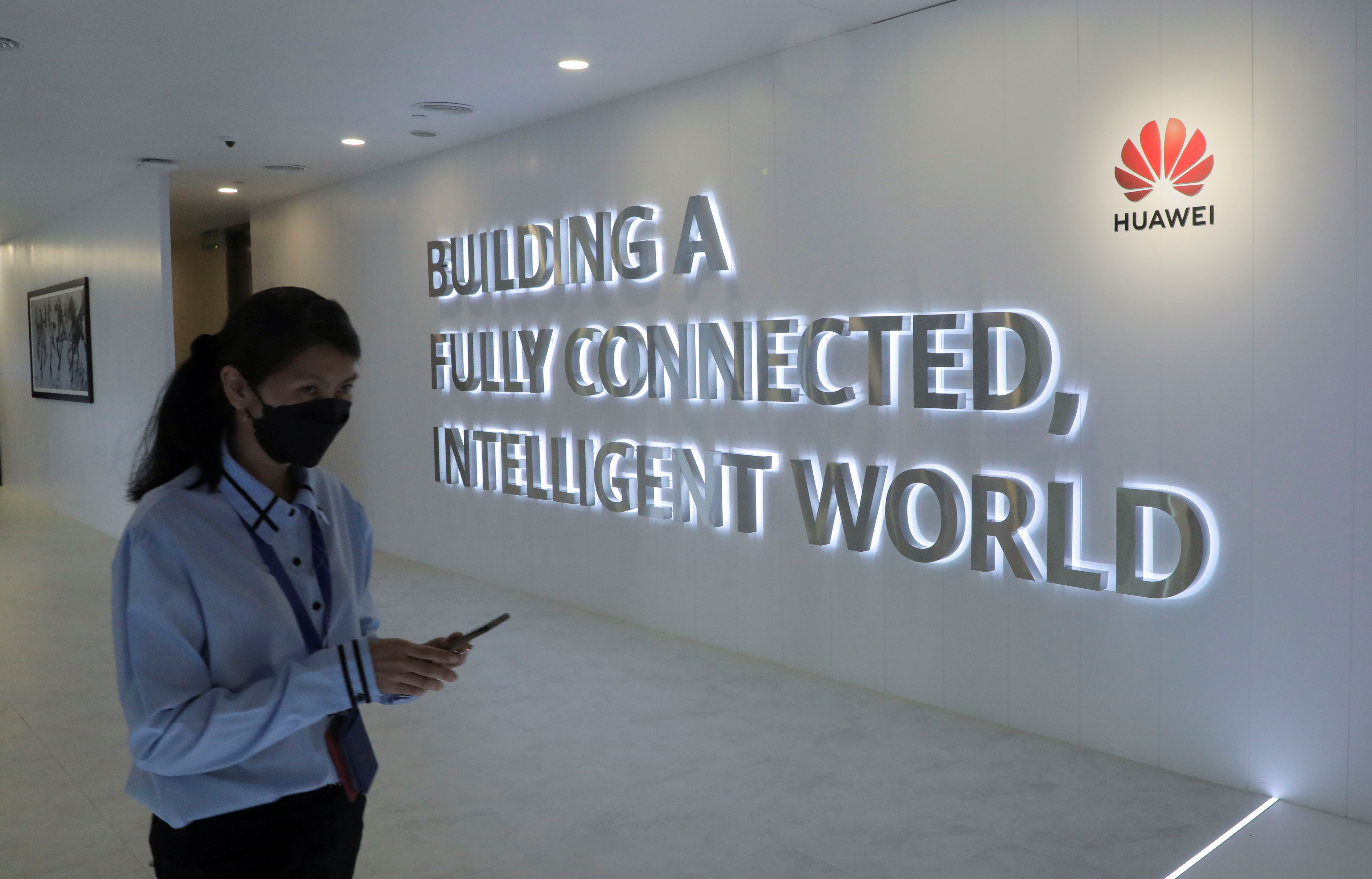 A Huawei's staff uses her smartphone at the telecommunication company's Customer Experience Centre in Kuala Lumpur