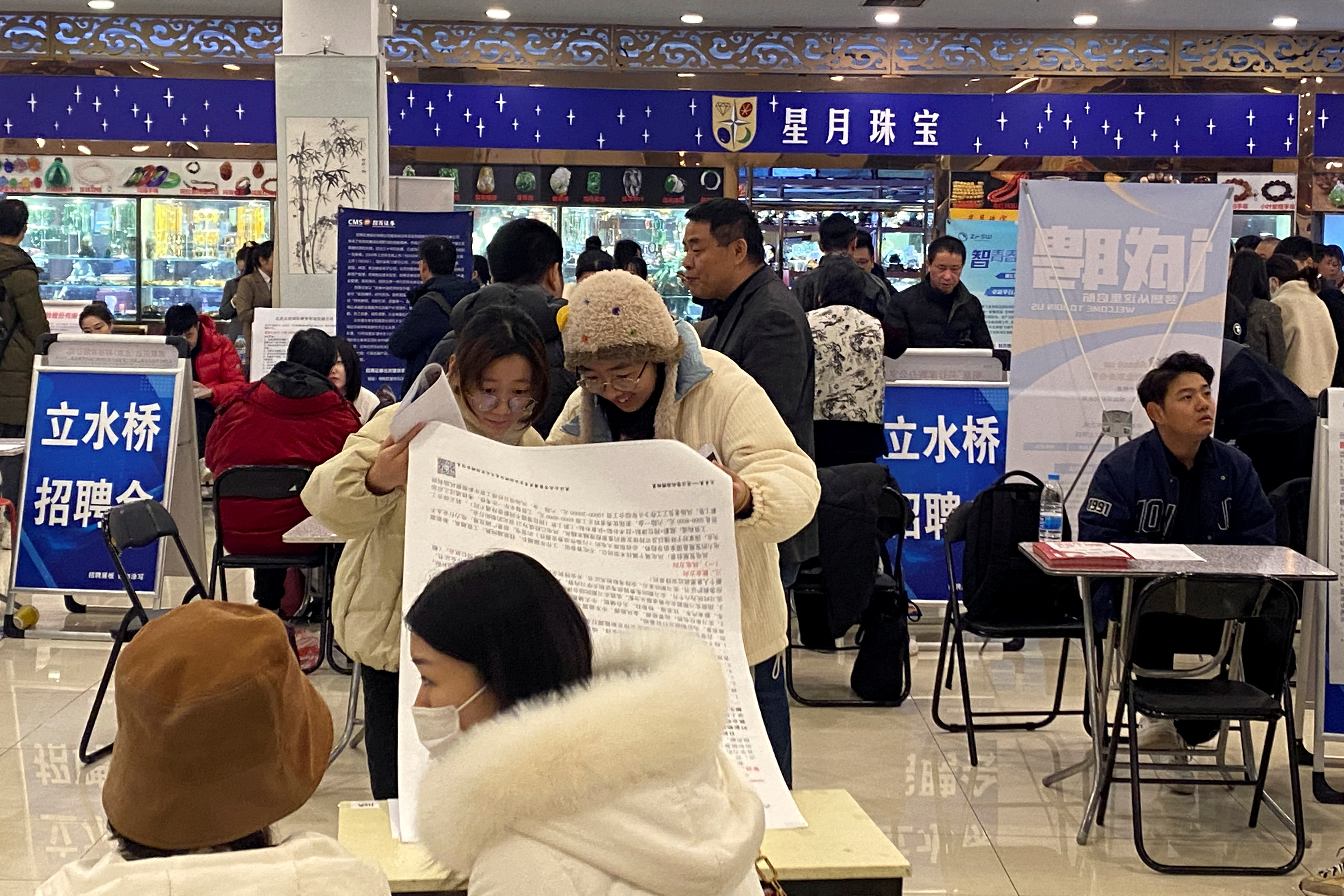 People attend a job fair in Beijing