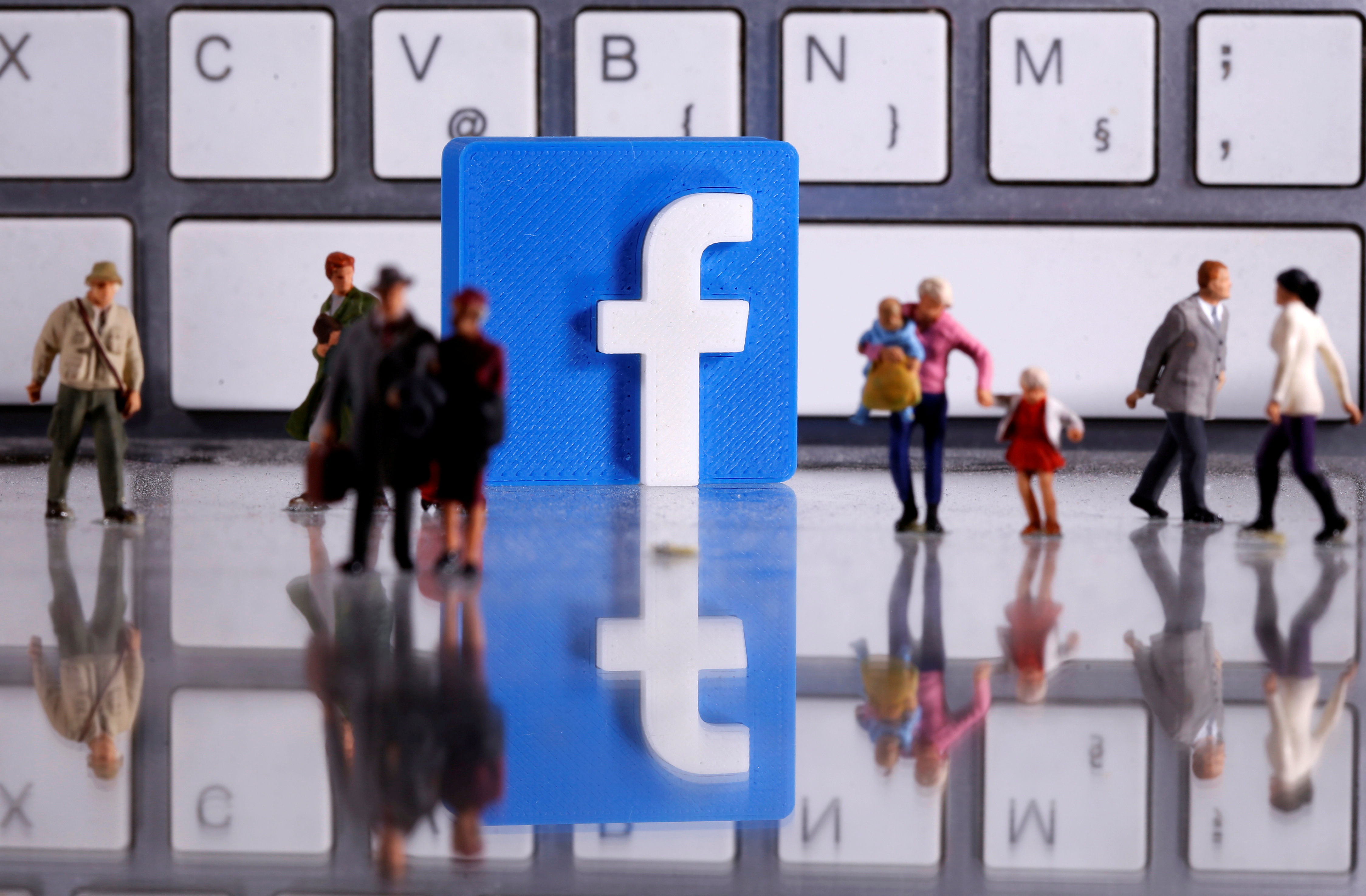 A 3D-printed Facebook logo is placed between small toy people figures in front of a keyboard in this illustration taken April 12, 2020. REUTERS/Dado Ruvic/Illustration/File Photo