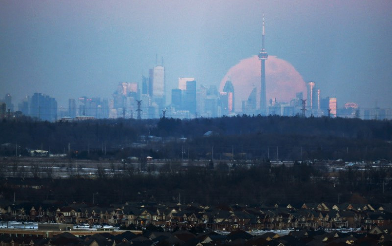 The moon rises over the Toronto city skyline as seen from Milton, Ontario