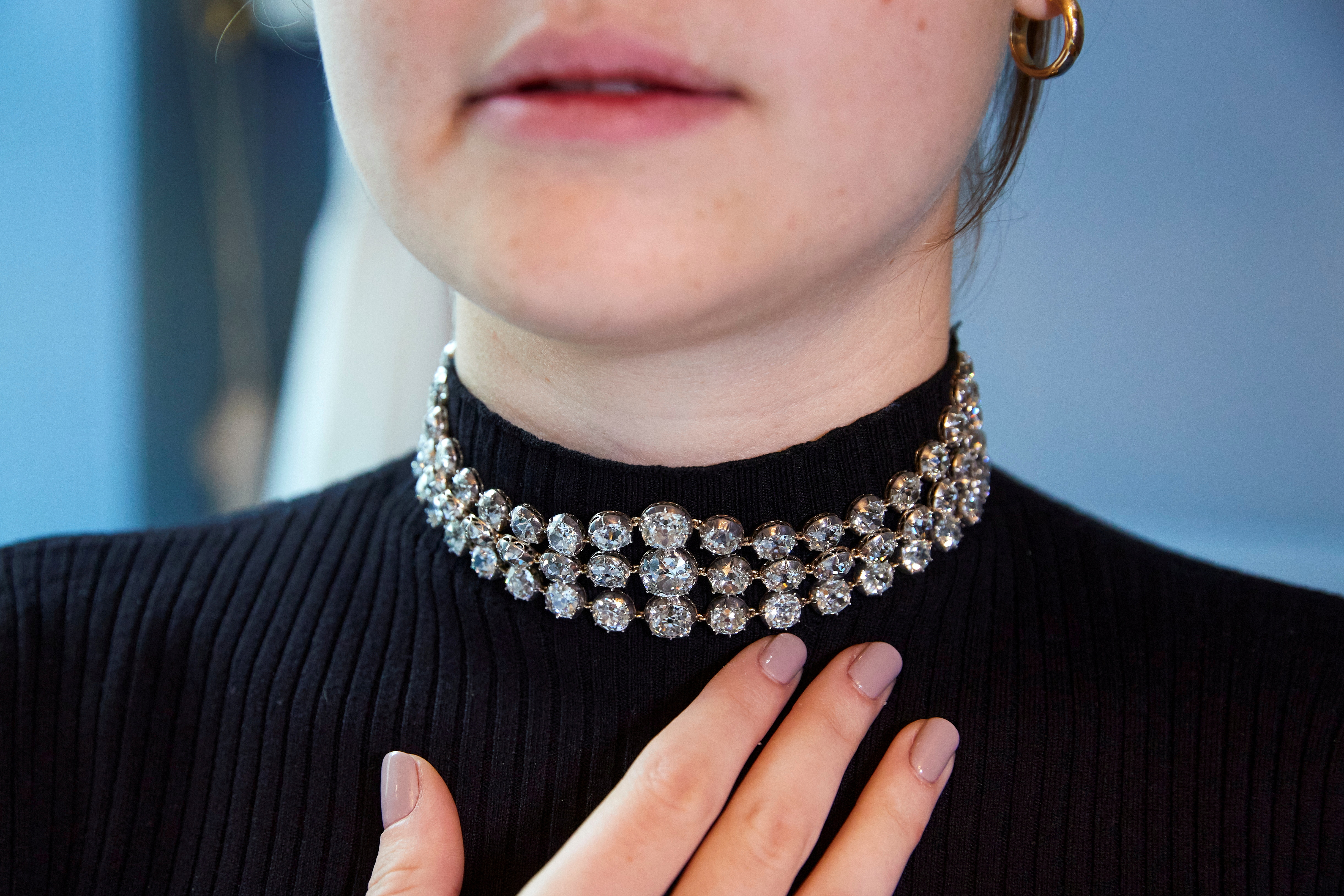 A staff wears a pair of diamond bracelets before their auction sale in Geneva