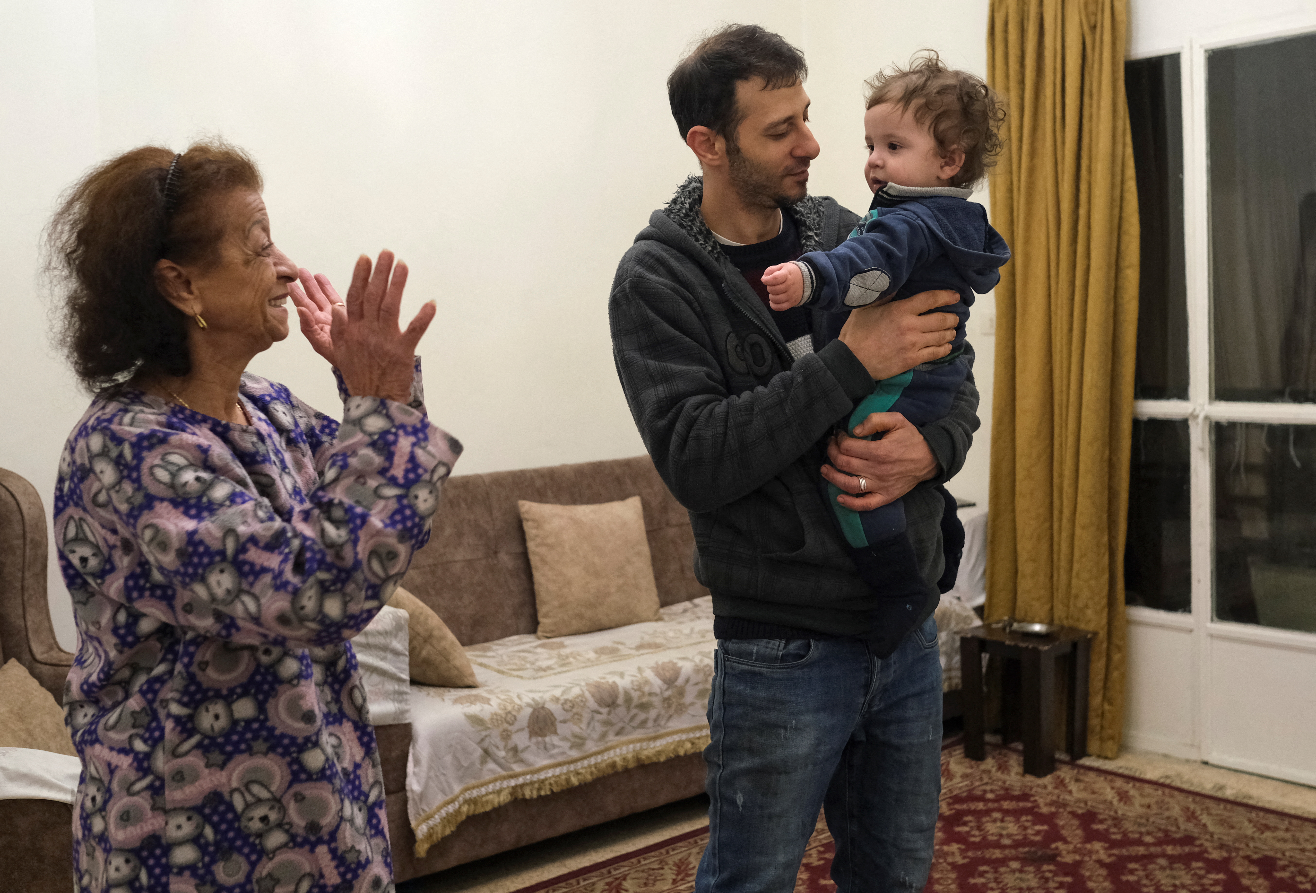 Shadi Ali Hamoud's mother gestures as she plays with her grandson at their house in Beirut