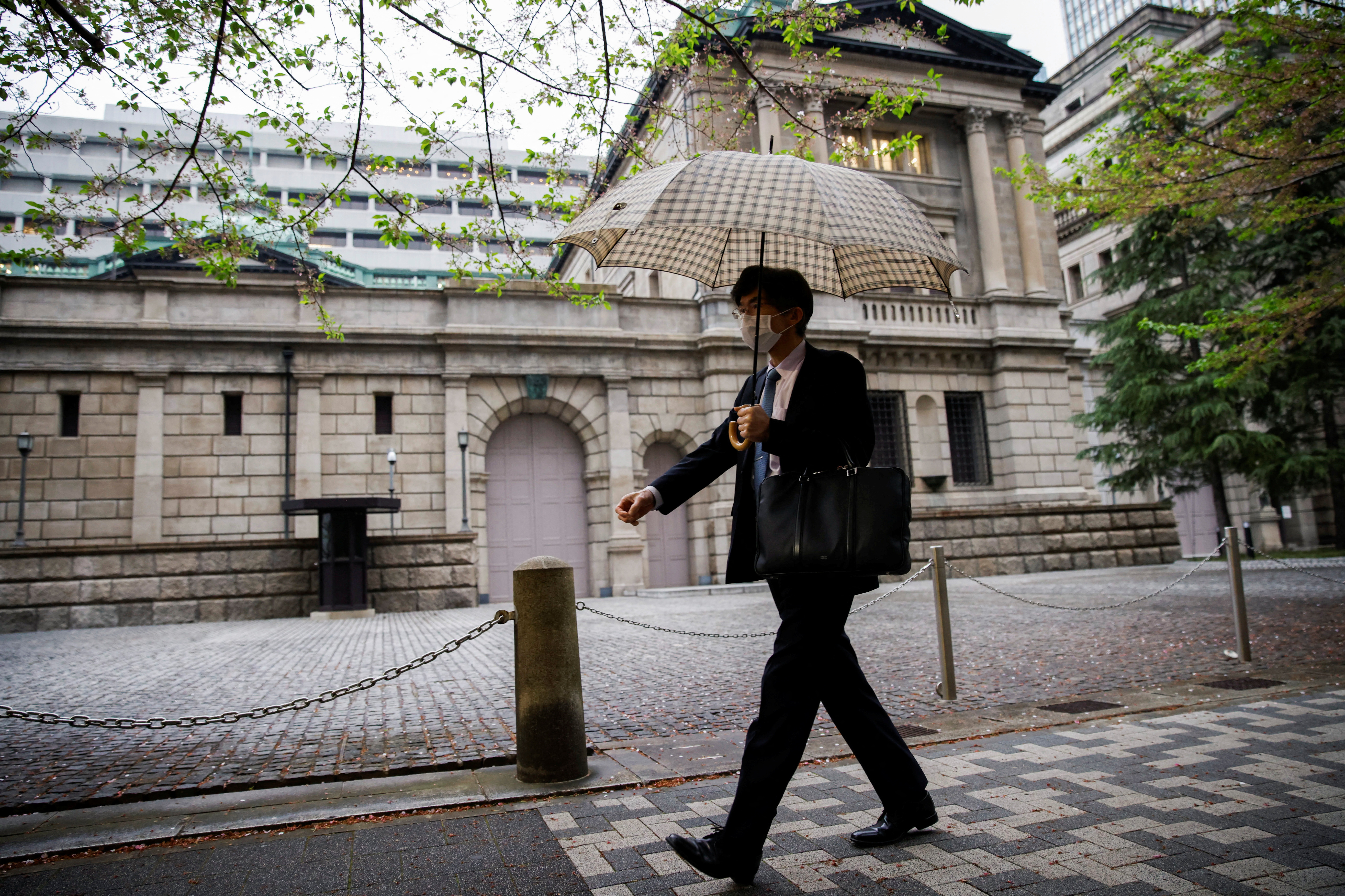 Office employee walks in front of the bank of Japan building in Tokyo