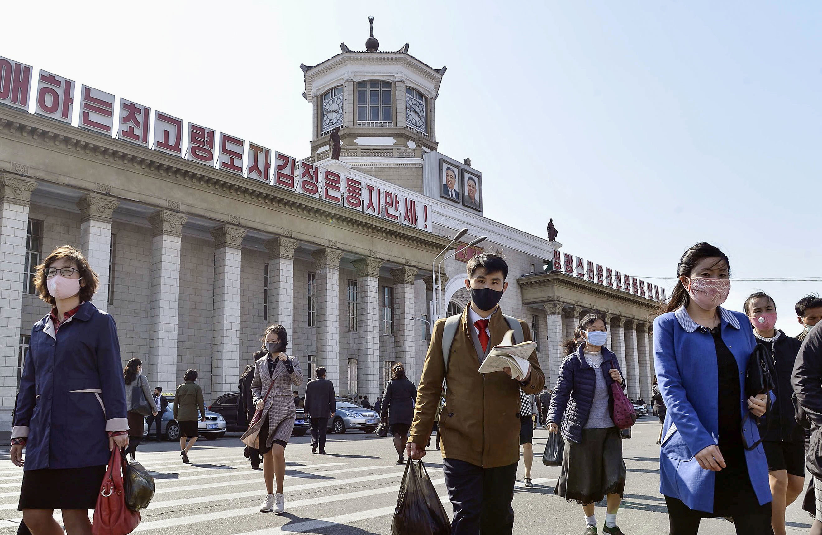 FILE PHOTO: People wearing protective face masks walk amid concerns over the new coronavirus disease in Pyongyang, North Korea