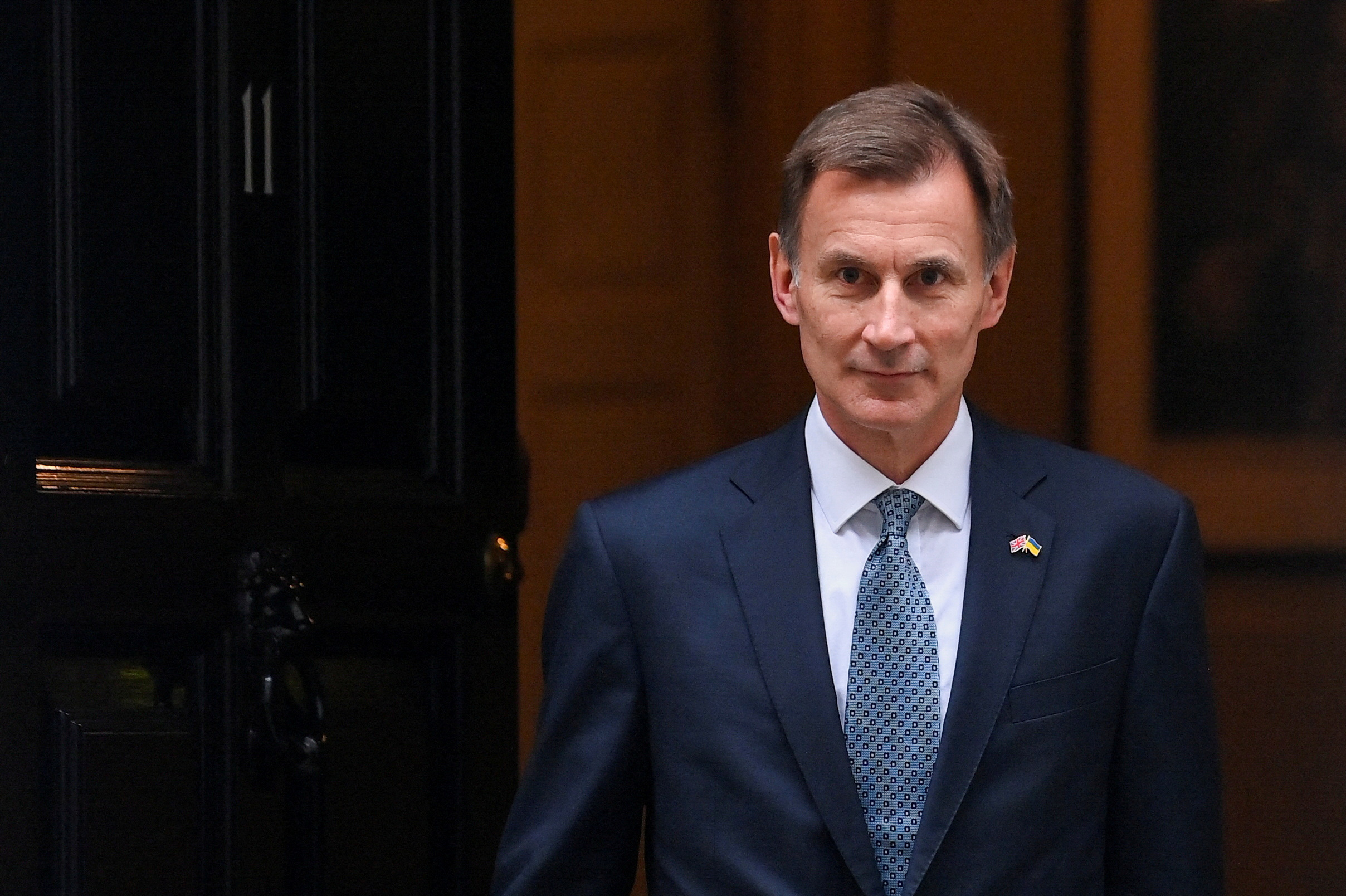 Britain's Chancellor of the Exchequer Jeremy Hunt walks at Downing Street in London