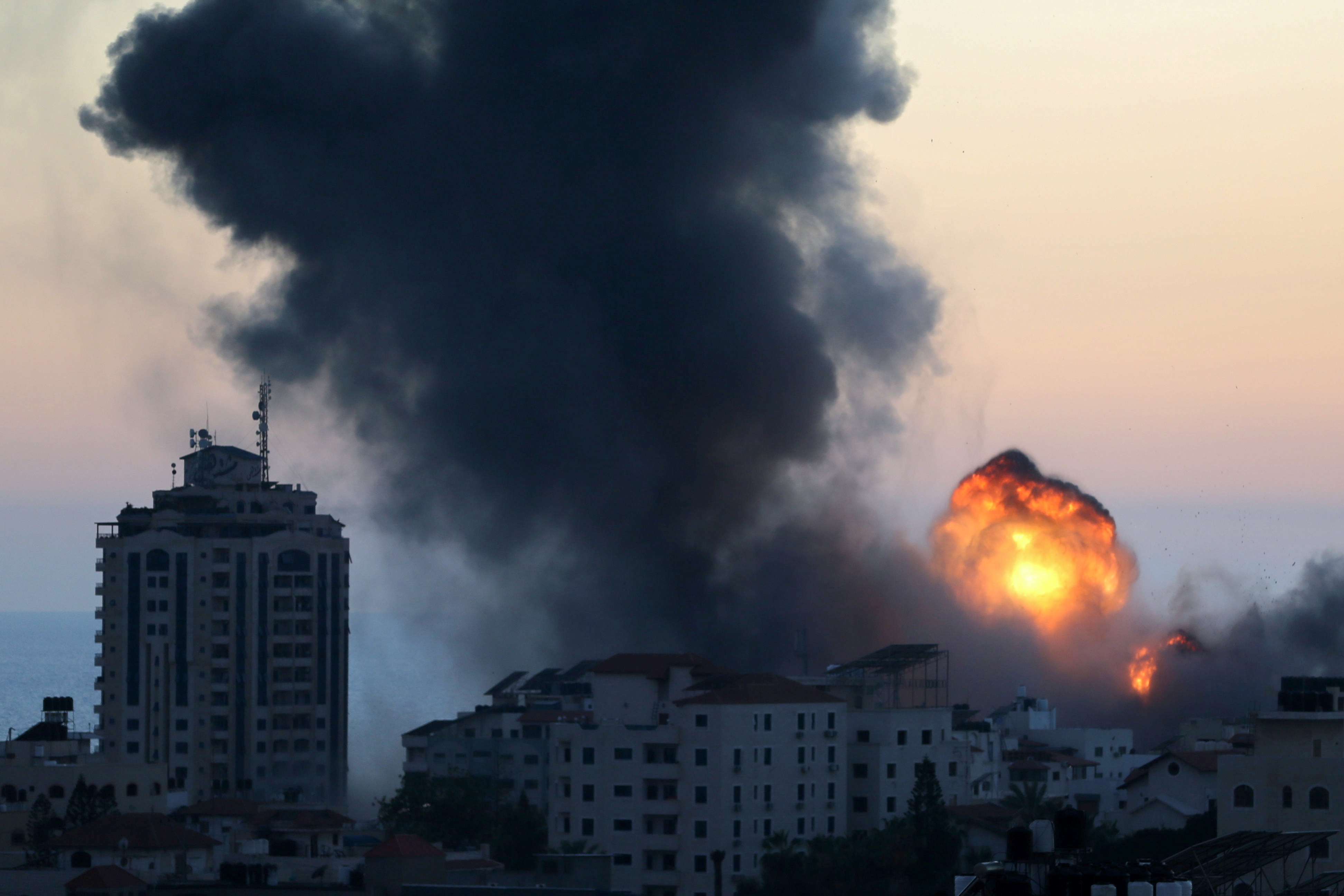 Smoke and flame rise during Israeli air strikes, as cross-border violence between the Israeli military and Palestinian militants continues, in Gaza City, May 14, 2021. REUTERS/Ibraheem Abu Mustafa