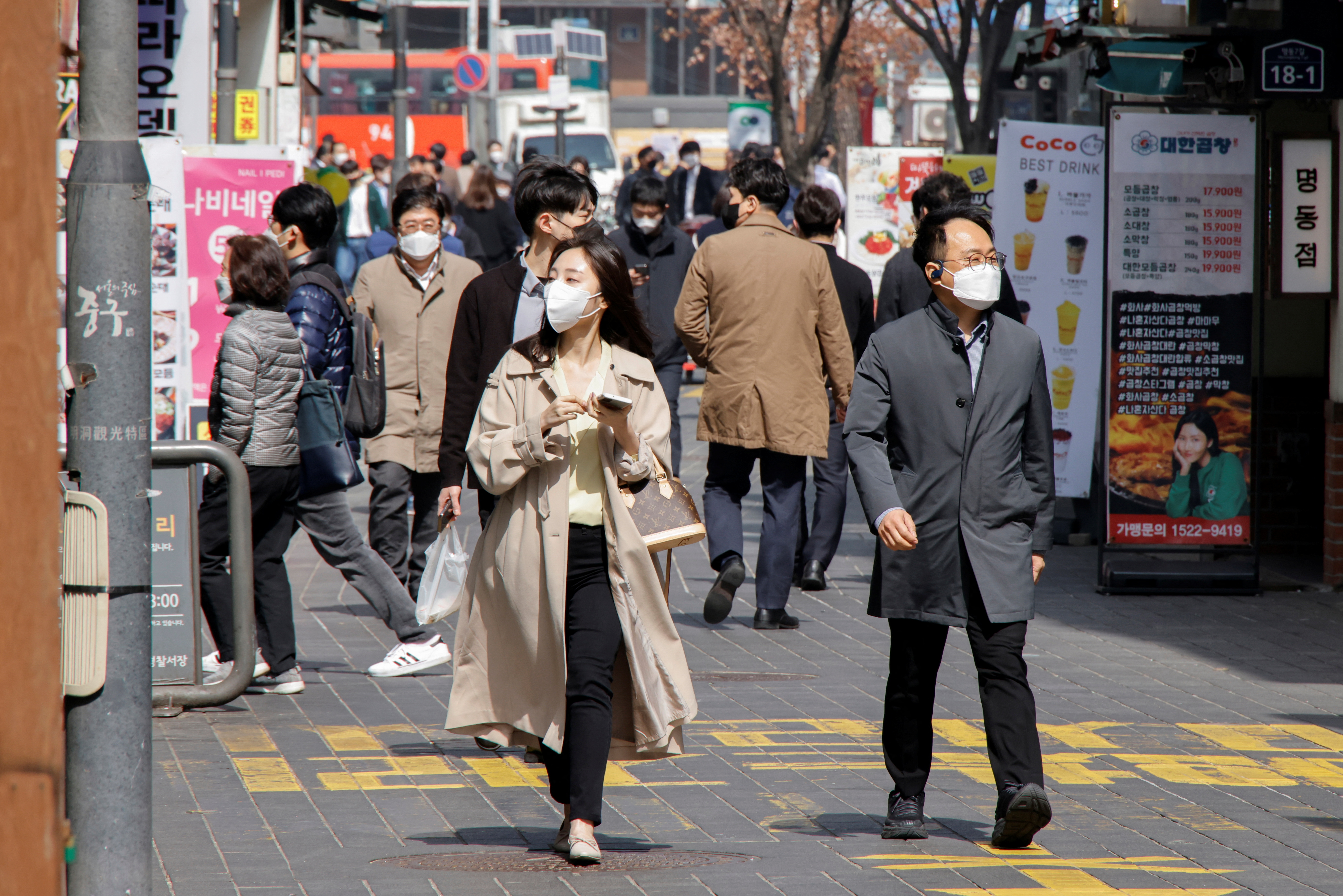 People wearing masks walk in a shopping district amid the coronavirus disease (COVID-19) pandemic in Seoul