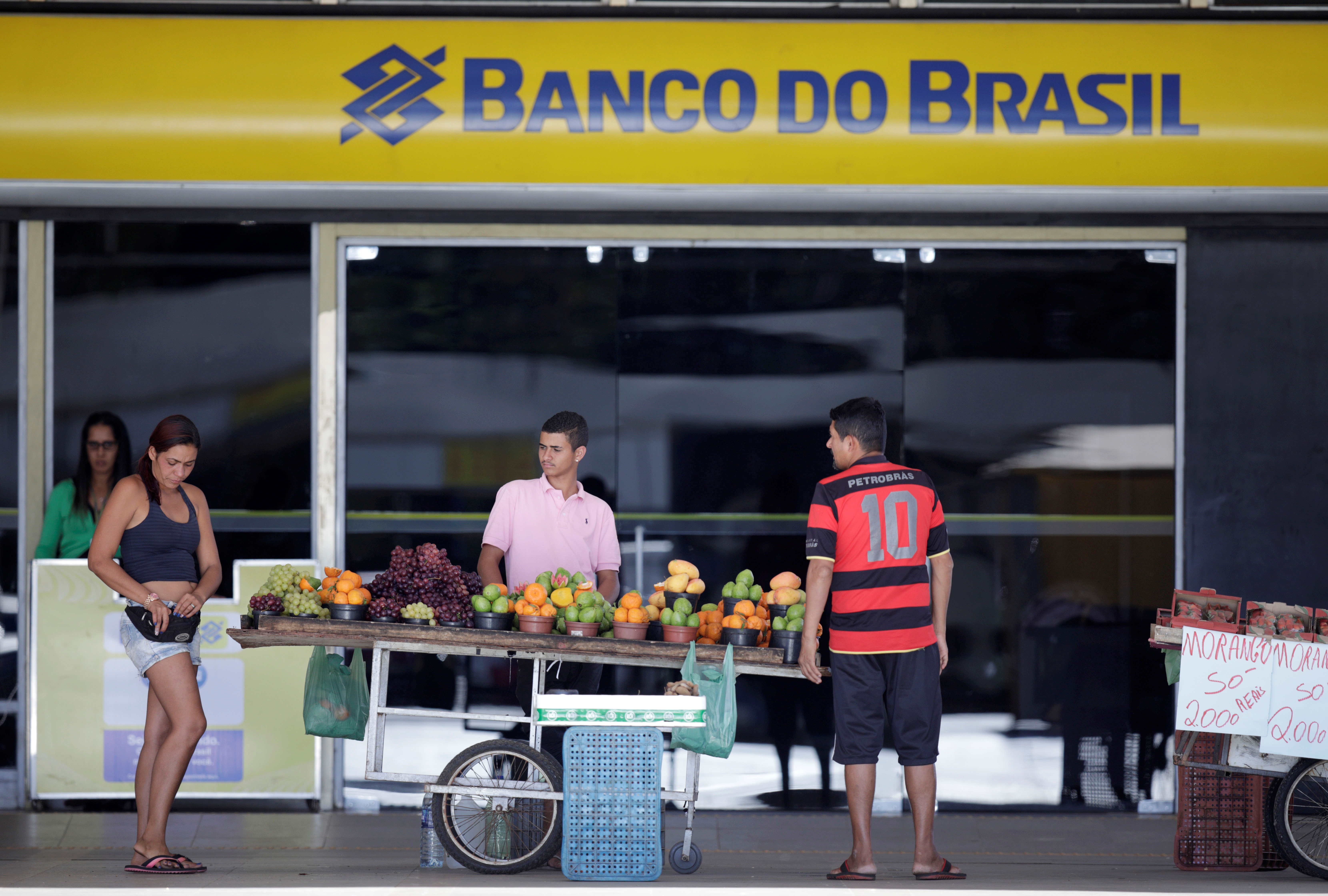 Street vendors are seen in front of a Banco do Brasil branch in Brasilia