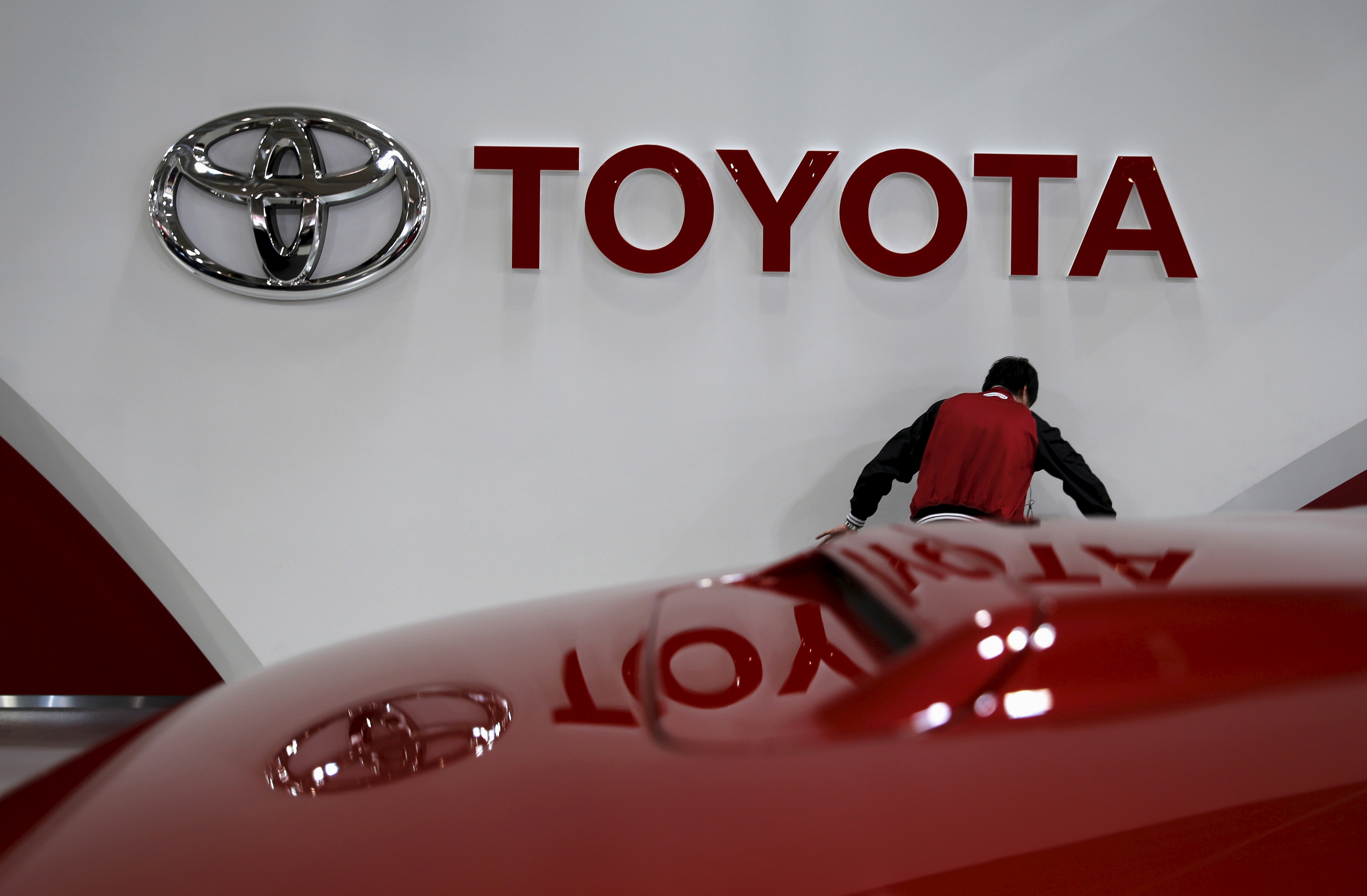 An employee works under a Toyota Motor Corp logo at the company's showroom in Tokyo