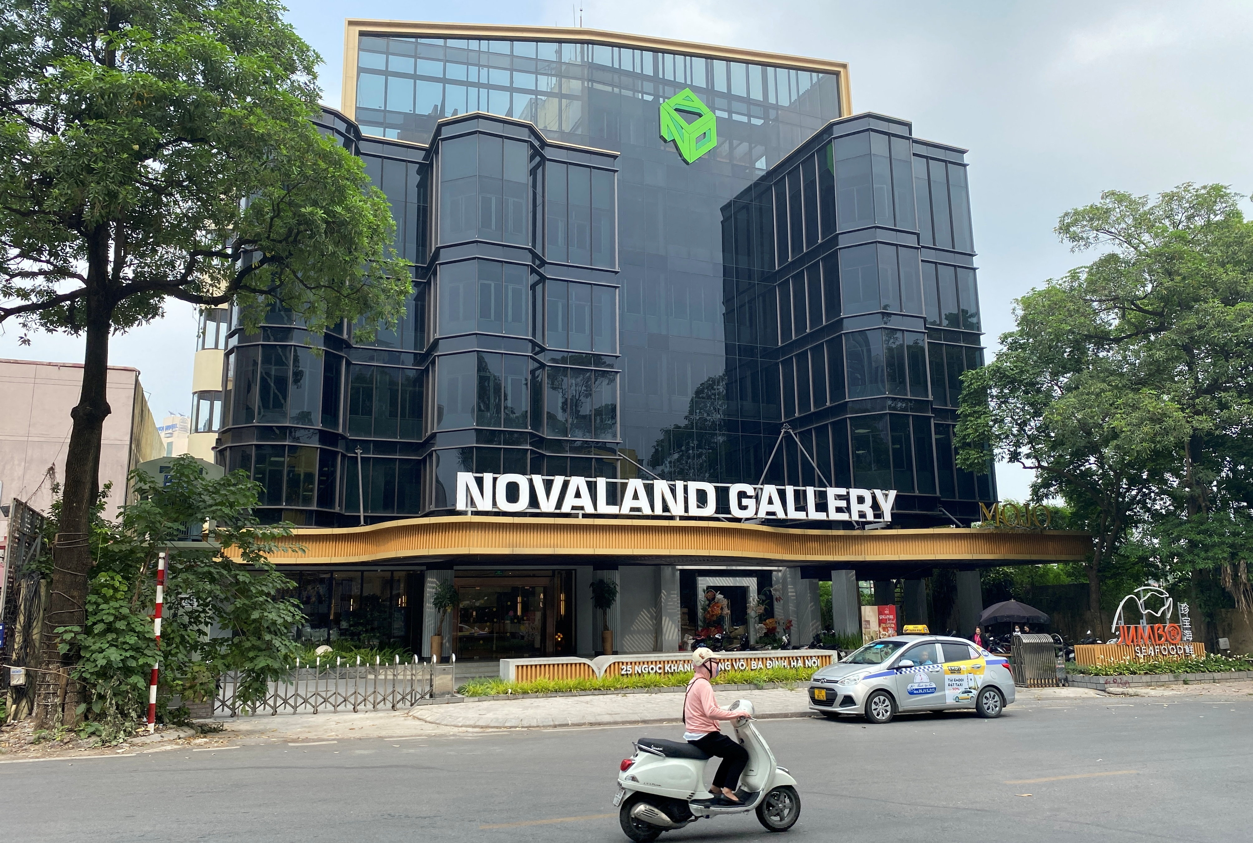 Motorbike drives past Vietnam's property giant No Va Land gallery in Hanoi, Vietnam