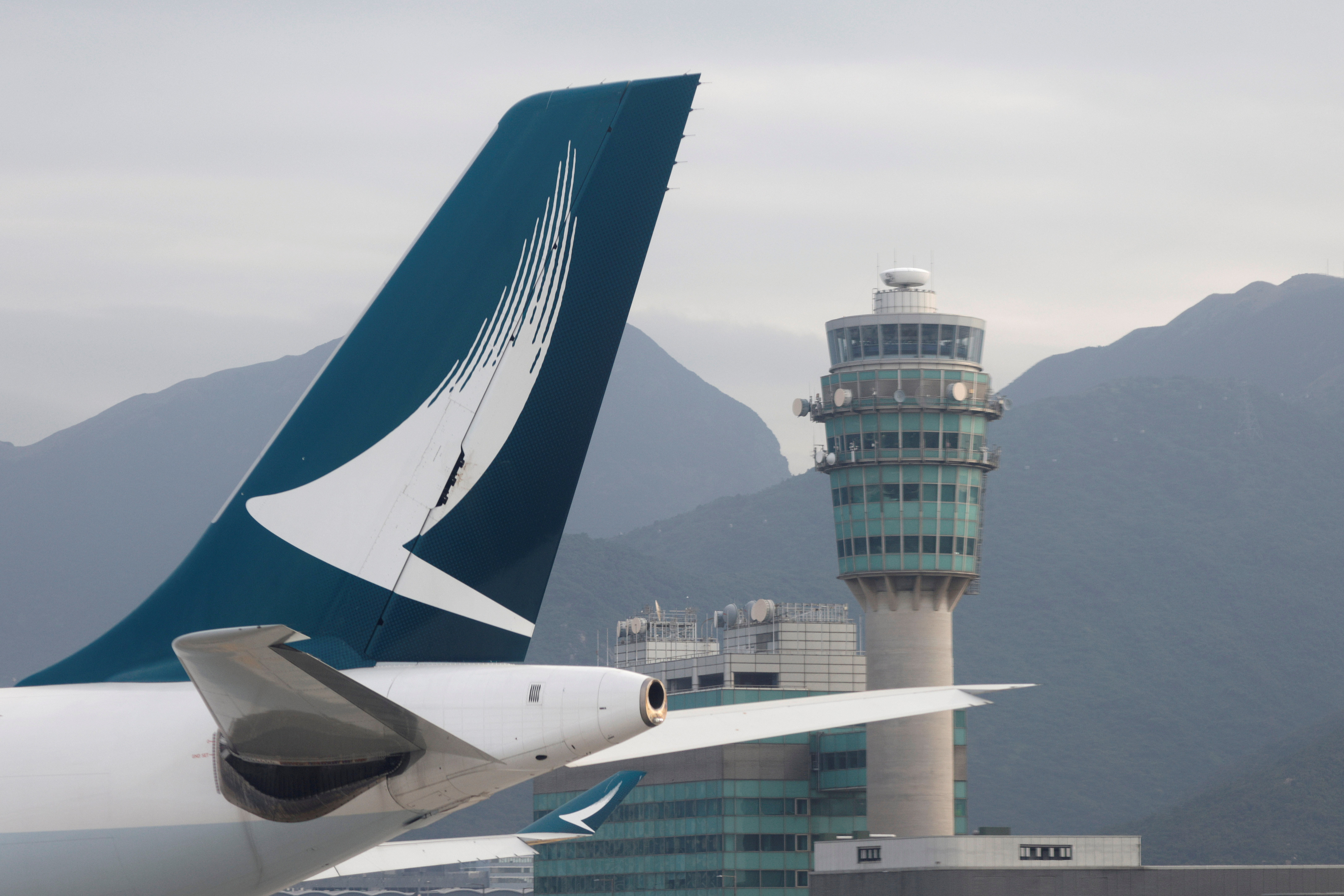 A Cathay Pacific jet is seen in front of air traffic control tower at the Hong Kong International Airport, Hong Kong