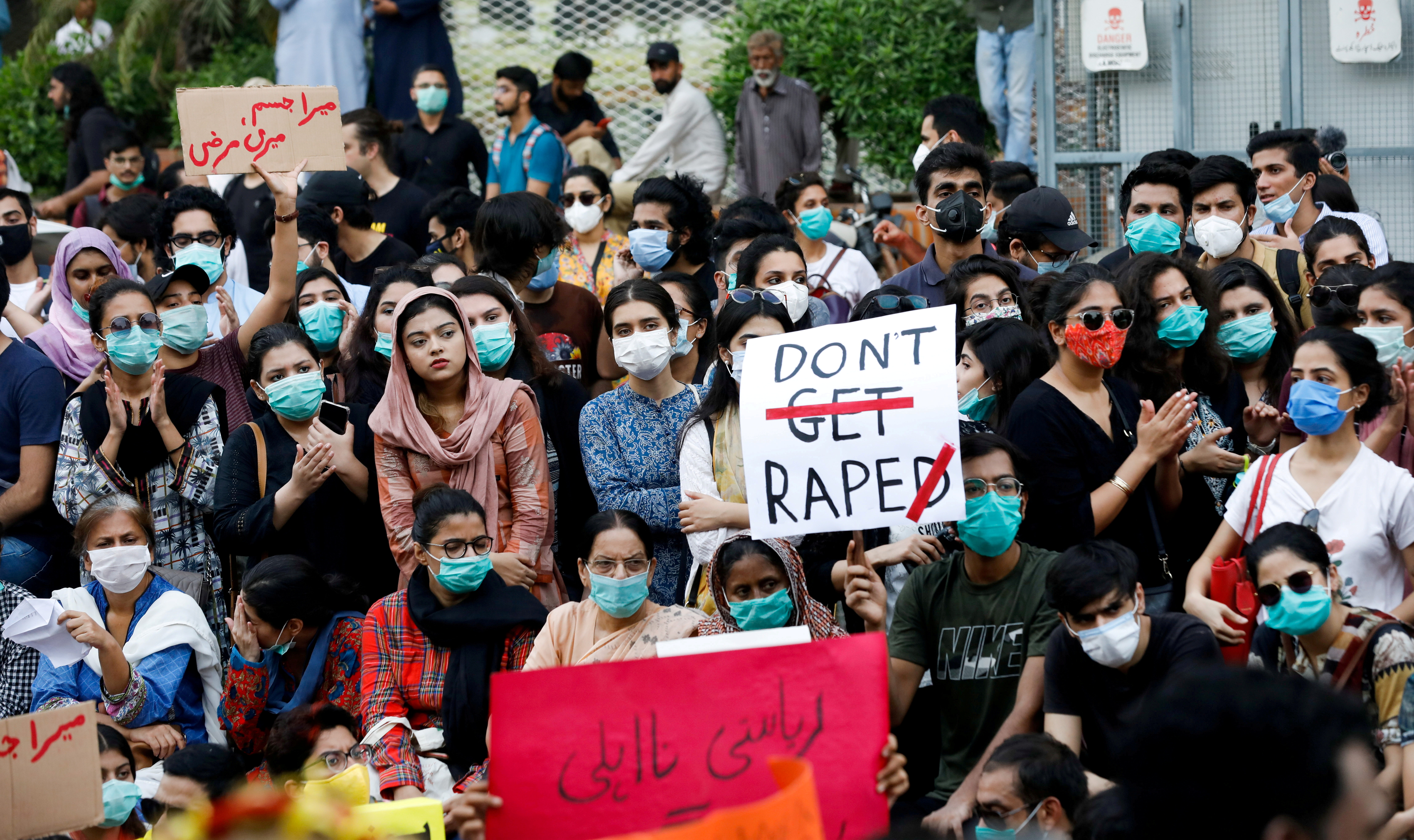 People carry signs to condemn violence against women and girls, during a protest in Karachi,