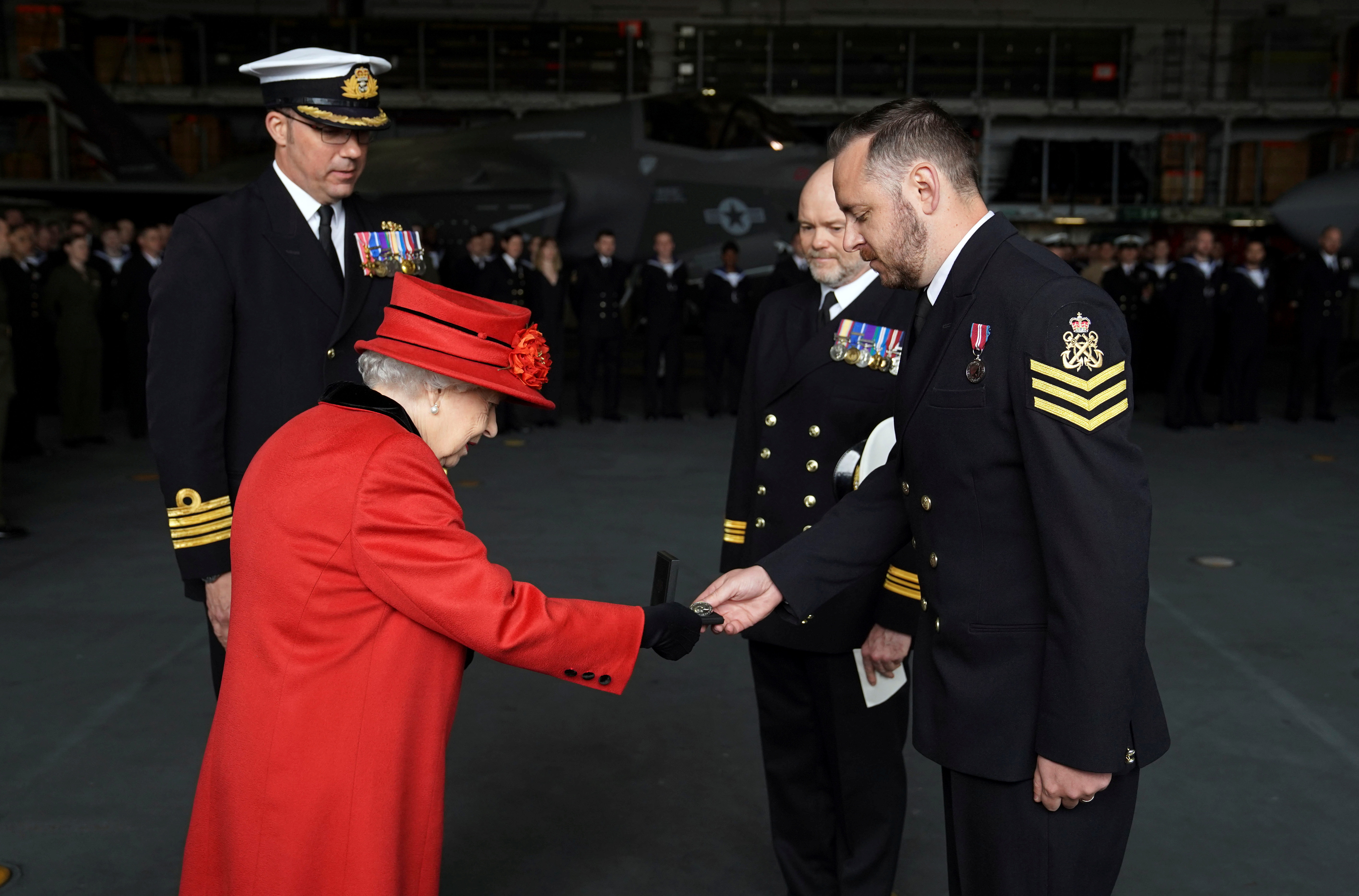 Britain's Queen Elizabeth presents the 15 years long service and good conduct medal to Petty Officer Matthew Ready during a visit to HMS Queen Elizabeth ahead of the ship's maiden deployment at HM Naval Base in Portsmouth, Britain May 22, 2021. Steve Parsons/PA Wire/Pool via REUTERS