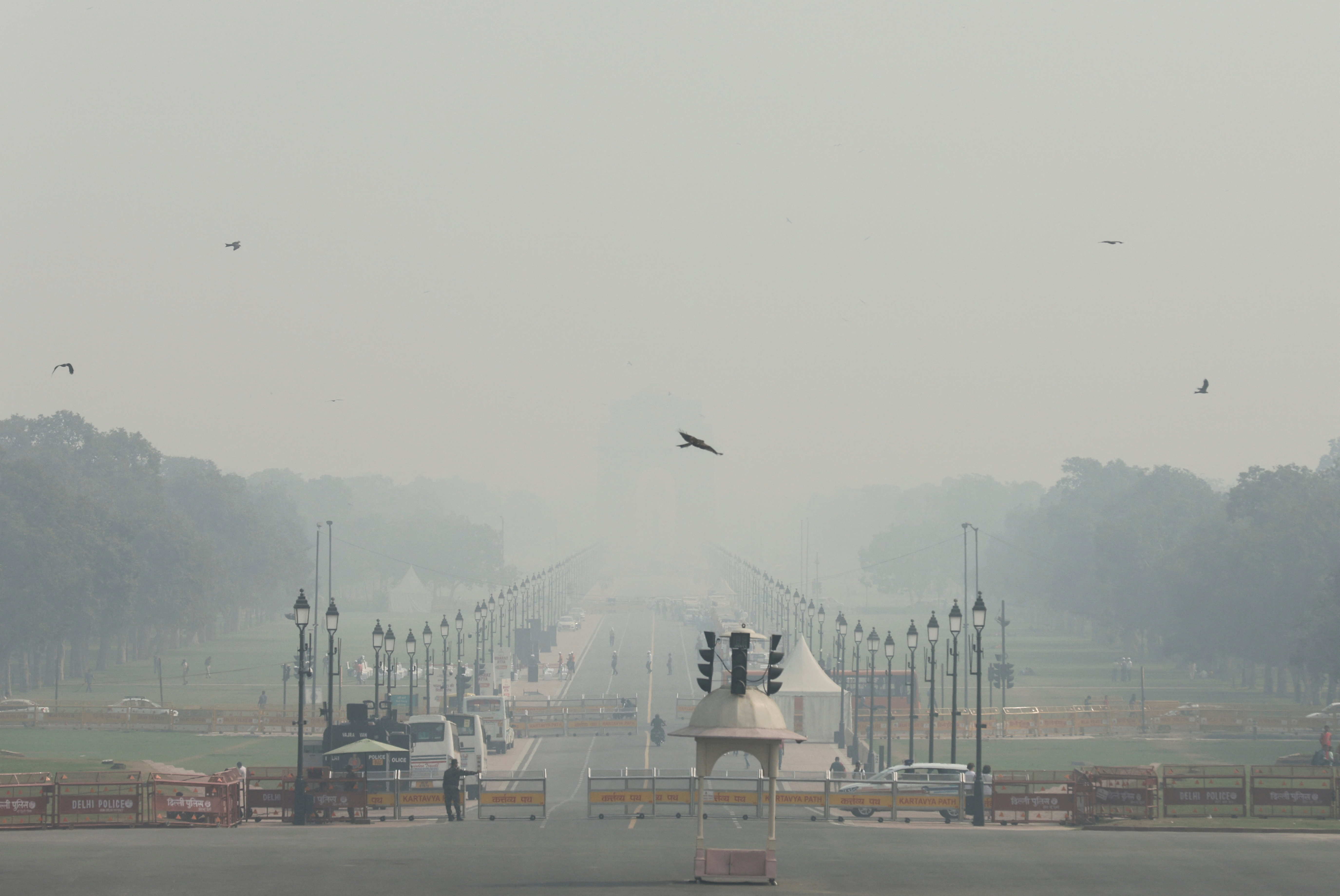 People walk on 'Kartavya Path' amidst the morning smog as air pollution levels decline in New Delhi