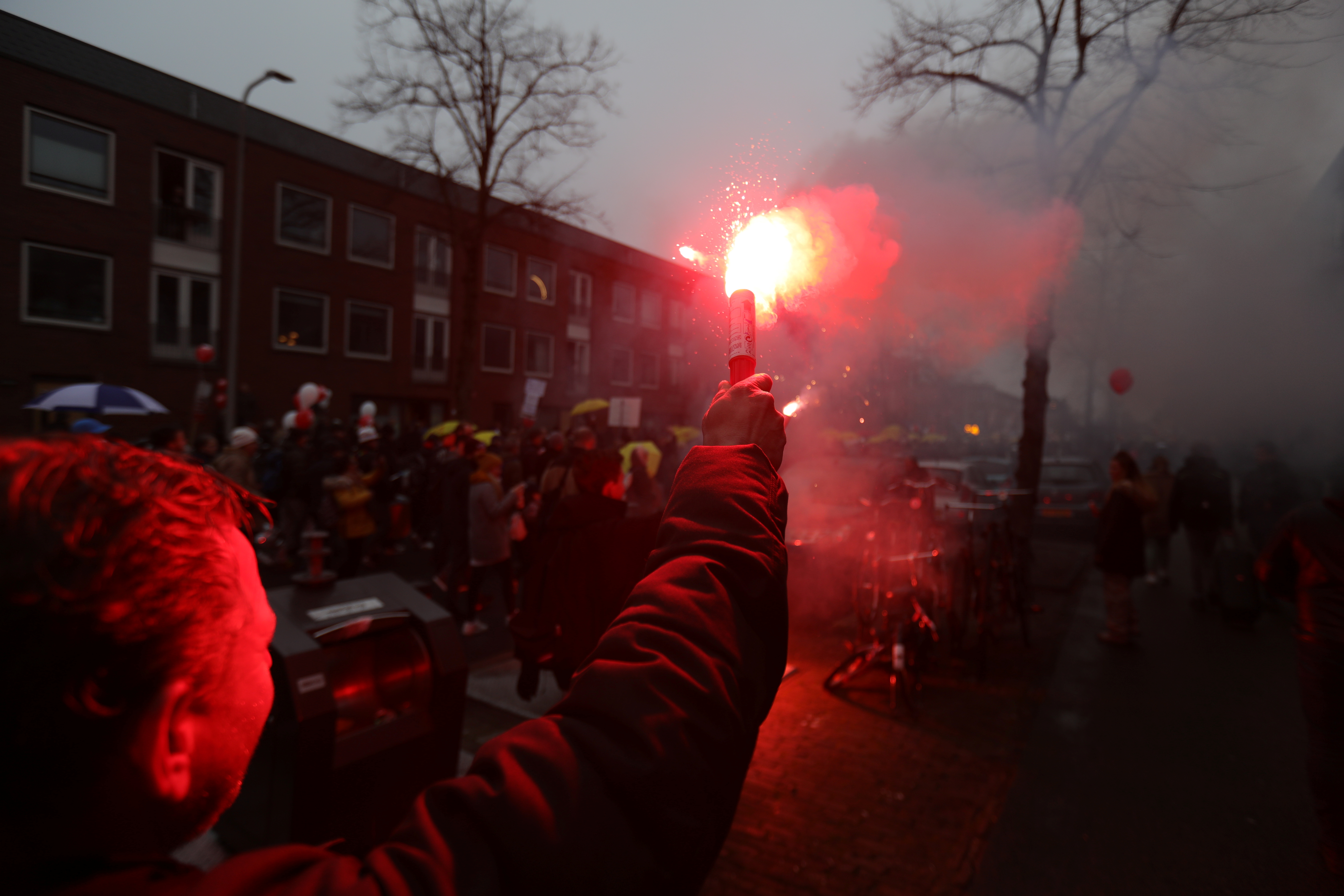 A person holding a flare attends a protest against new measures to fight a record surge of coronavirus disease (COVID-19) infections, in Utrecht, Netherlands, December 4, 2021. REUTERS/Eva Plevier