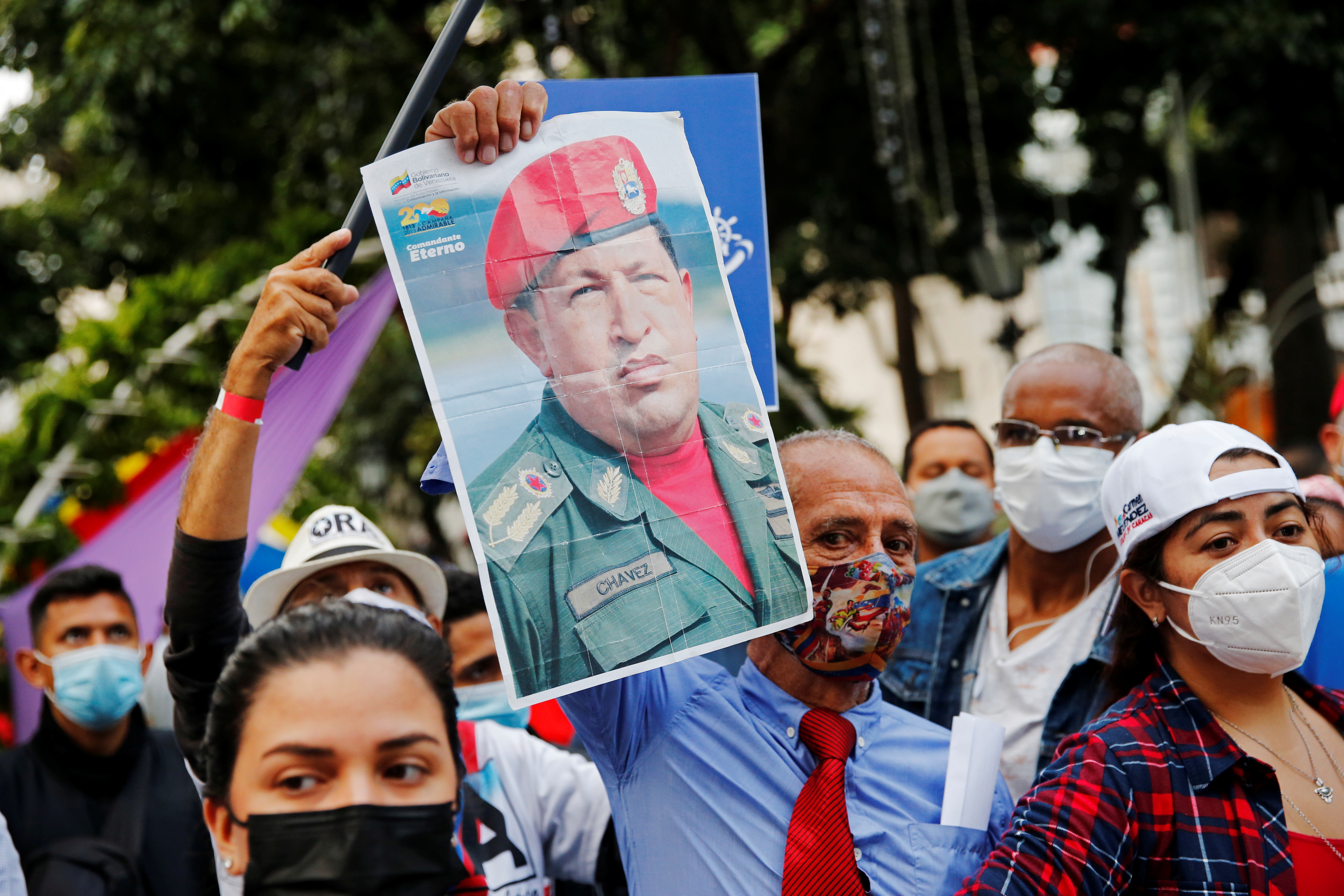 A pro-government supporter holds a poster of late Venezuelan president Hugo Chavez during an event by Carmen Melendez, the ruling party's candidate for mayor of Caracas, in Caracas, Venezuela October 29, 2021.   REUTERS/Leonardo Fernandez Viloria