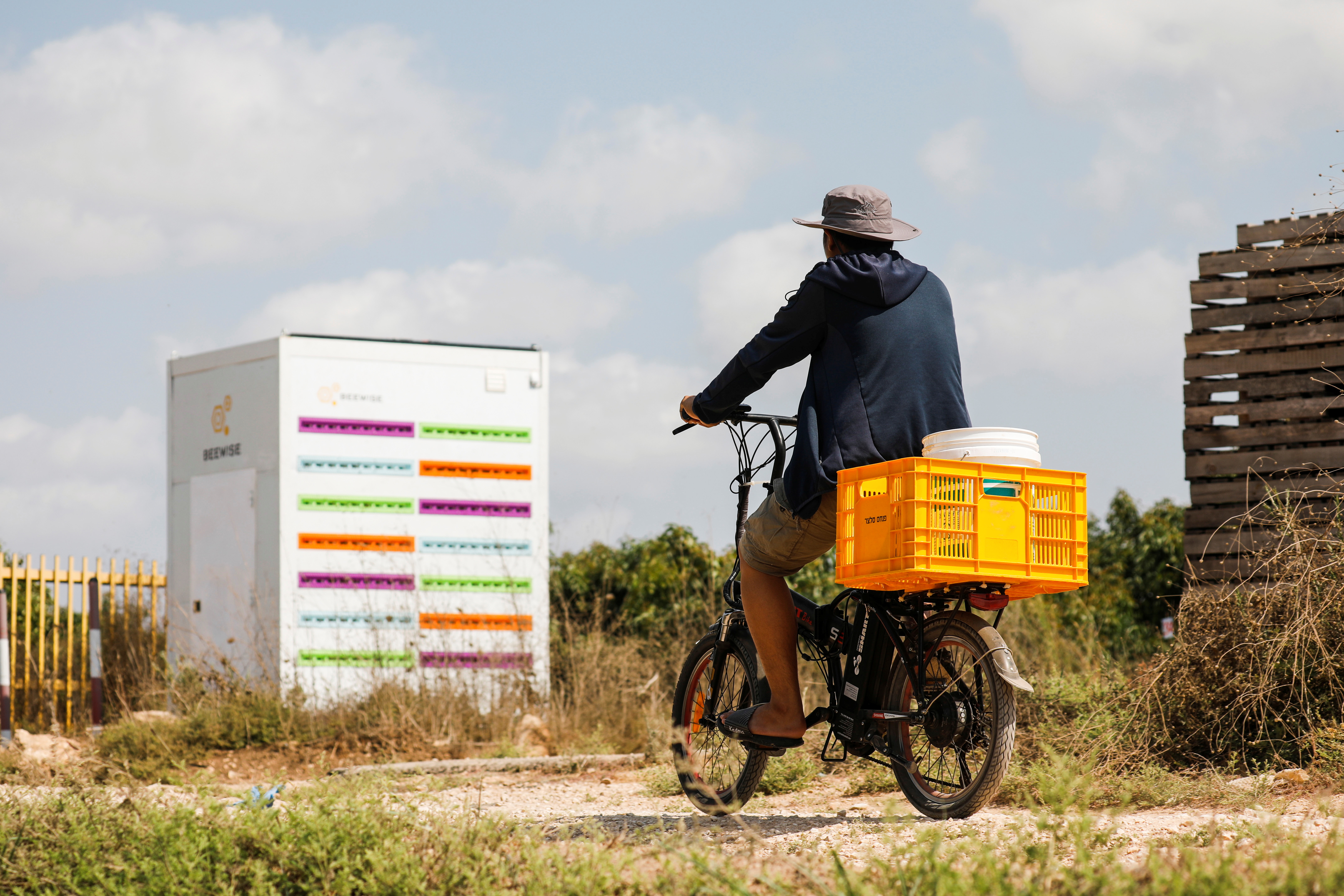 A man cycles next to a robotic beehive, developed by Israeli startup Beewise, in Beit Haemek
