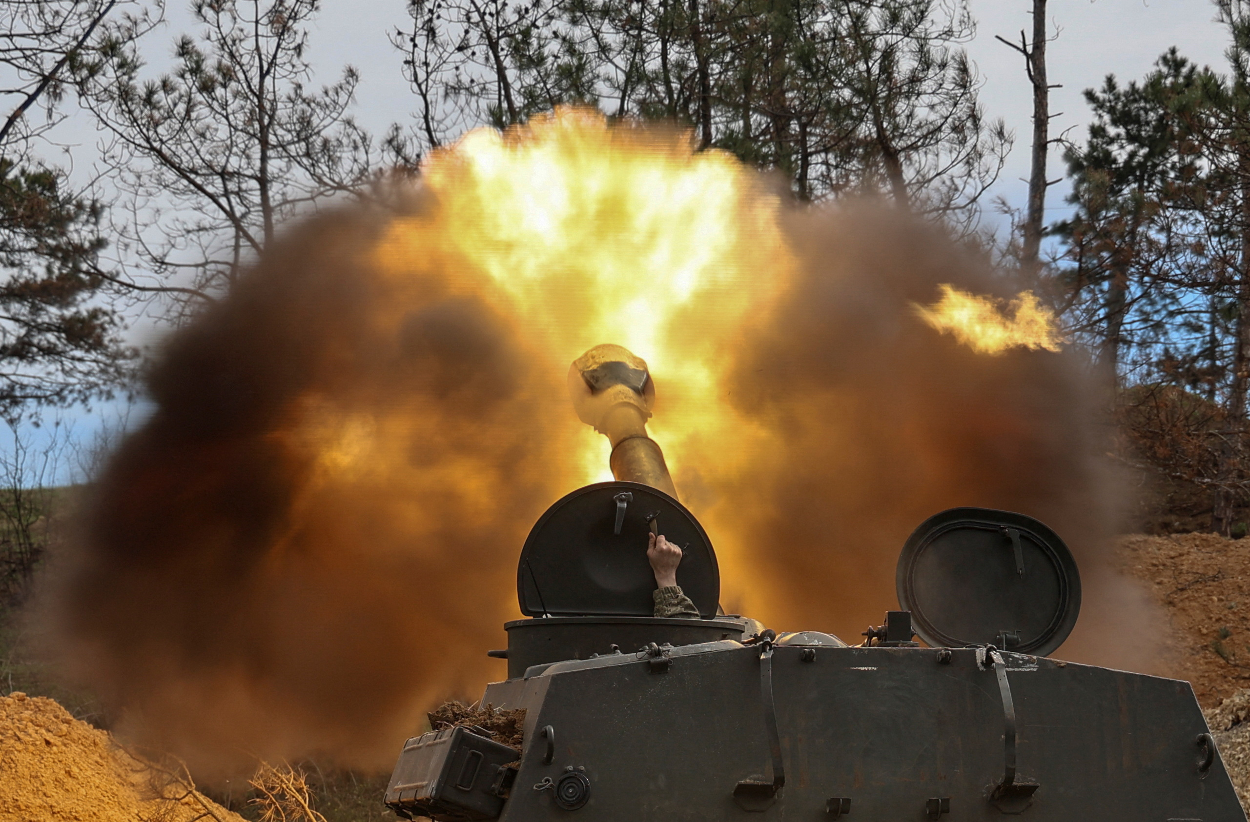 Ukrainian service members fire a self-propelled howitzer toward Russian troops in a front line in Southern Ukraine