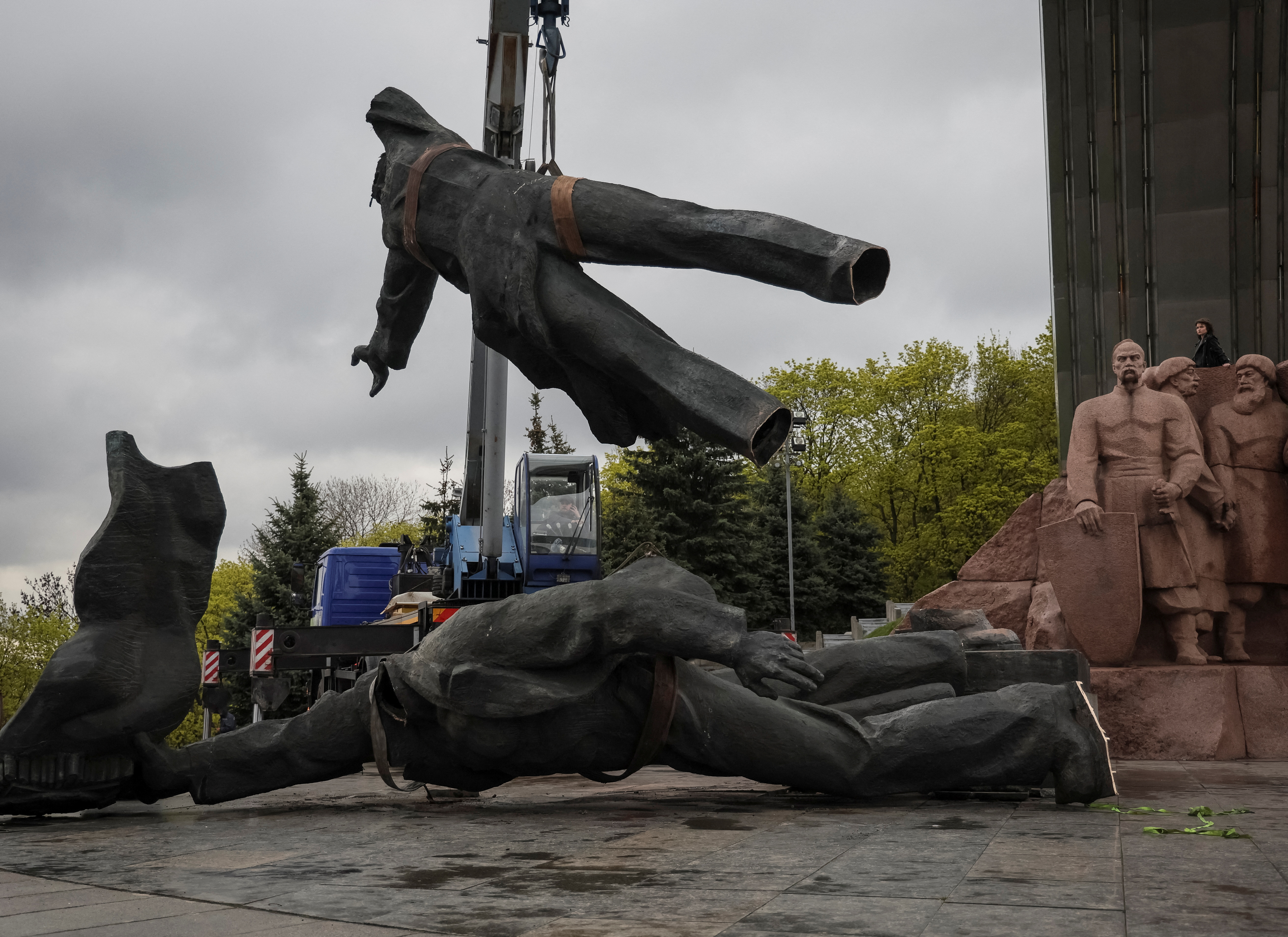 A Soviet monument to a friendship between Ukrainian and Russian nations is seen during its demolition in central Kyiv