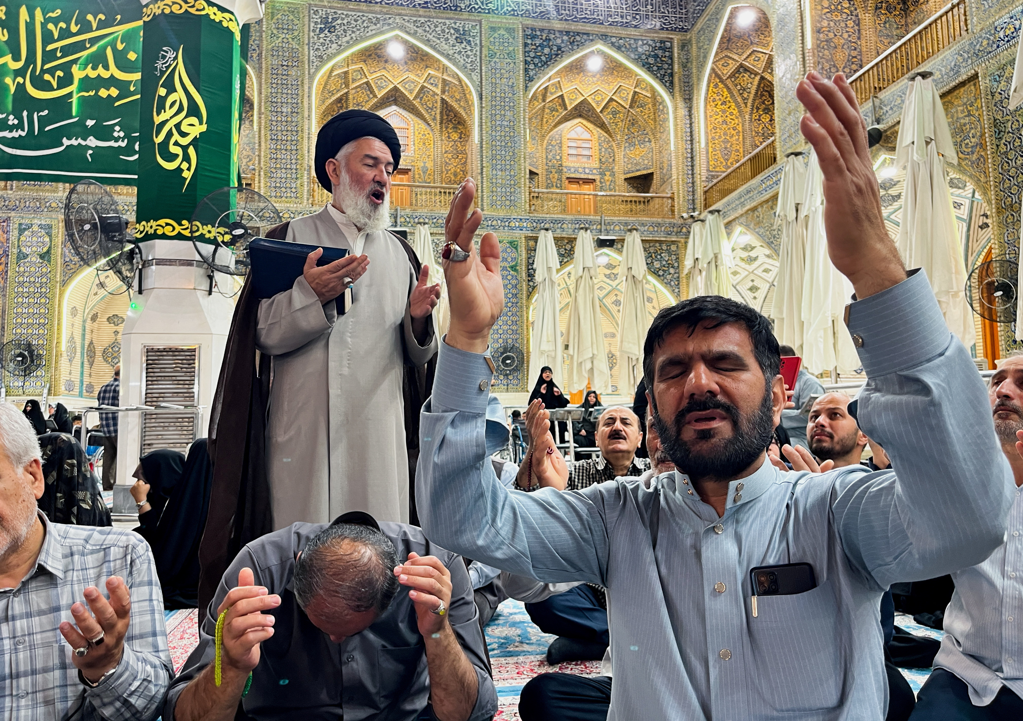 Iranian Shi'ite pilgrims pray for Iran's President Ebrahim Raisi following the crash of a helicopter carrying him, in Najaf