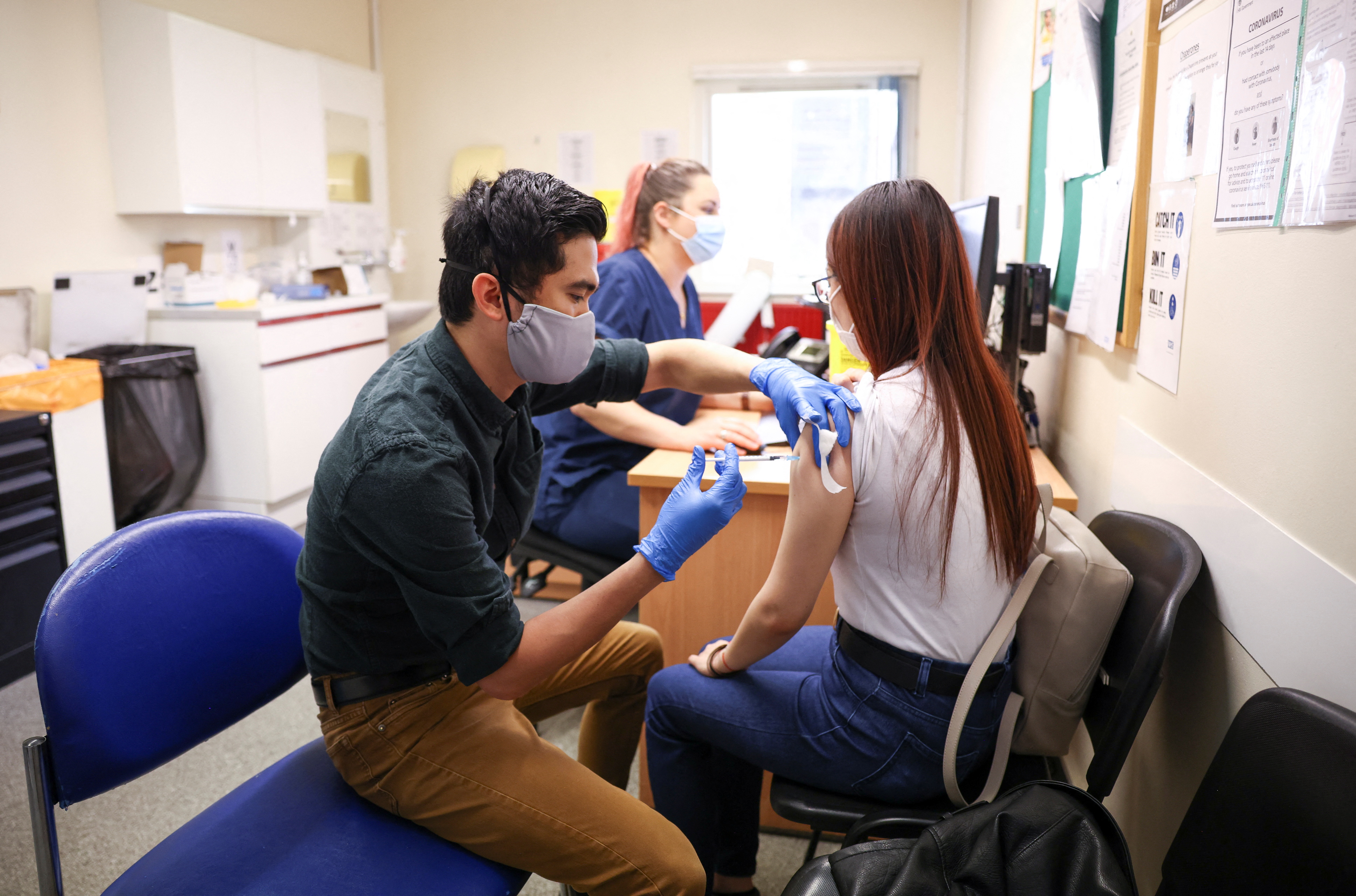 A person receives a dose of the Pfizer BioNTech vaccine, at vaccination centre for young people and students at the Hunter Street Health Centre, amid the coronavirus disease (COVID-19) outbreak, in London