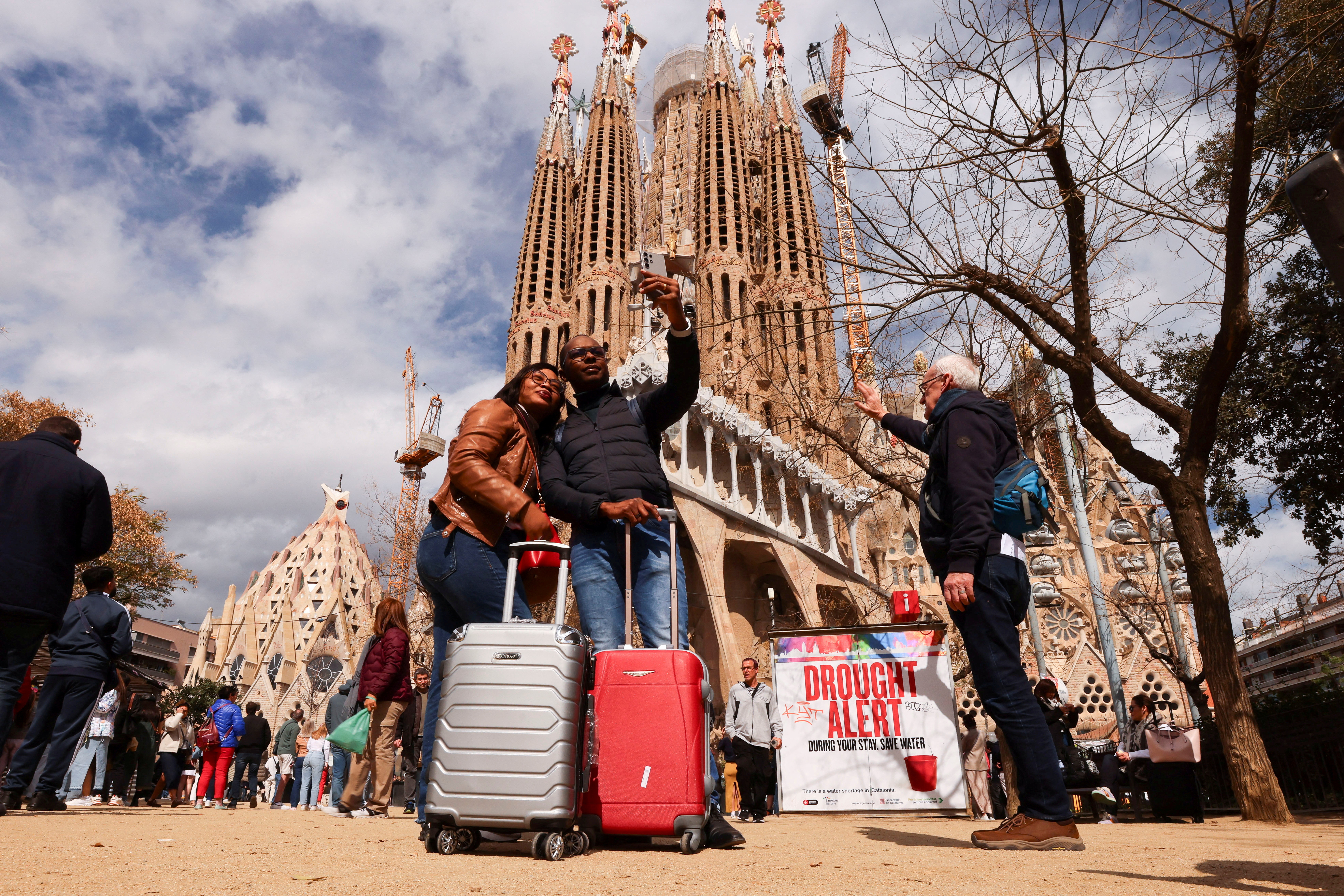 Tourists take a selfie next to a sign at the Sagrada Familia Basilica in Barcelona