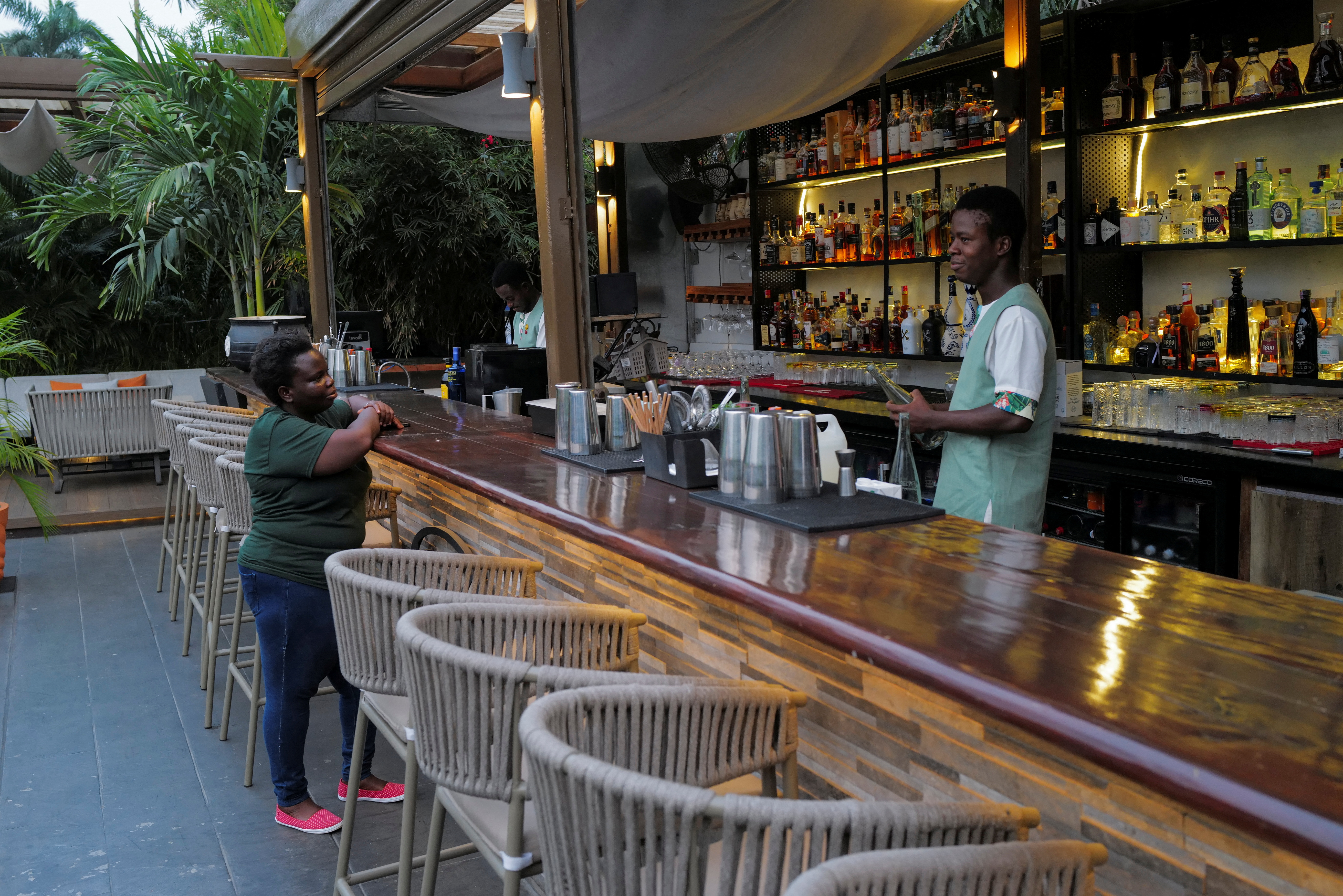 Benedicta Tamakloe, a coffe entrepreneur, interacts with a bartender in Accra