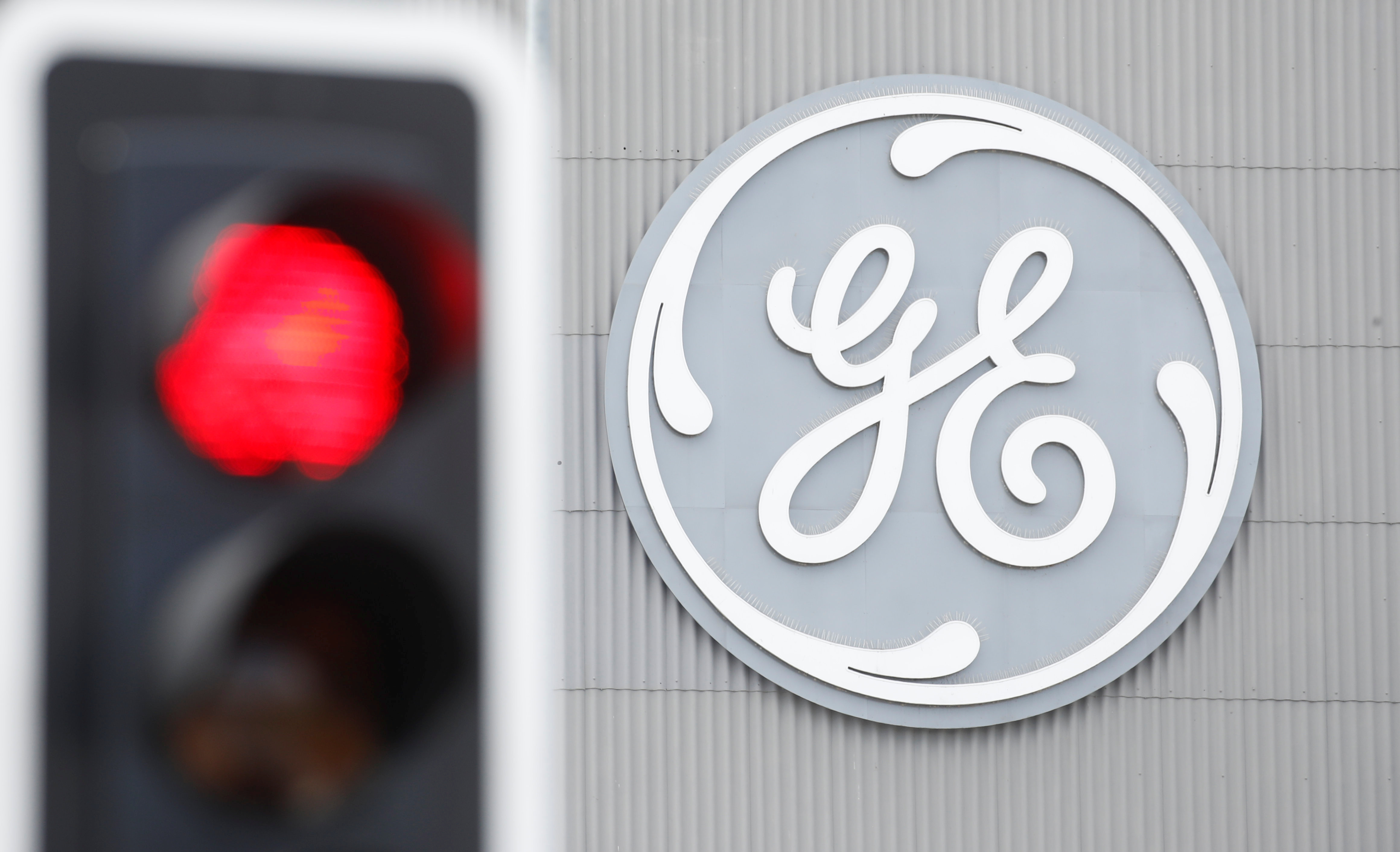 A traffic light is seen in front of a logo of General Electric at the company's plant in Birr