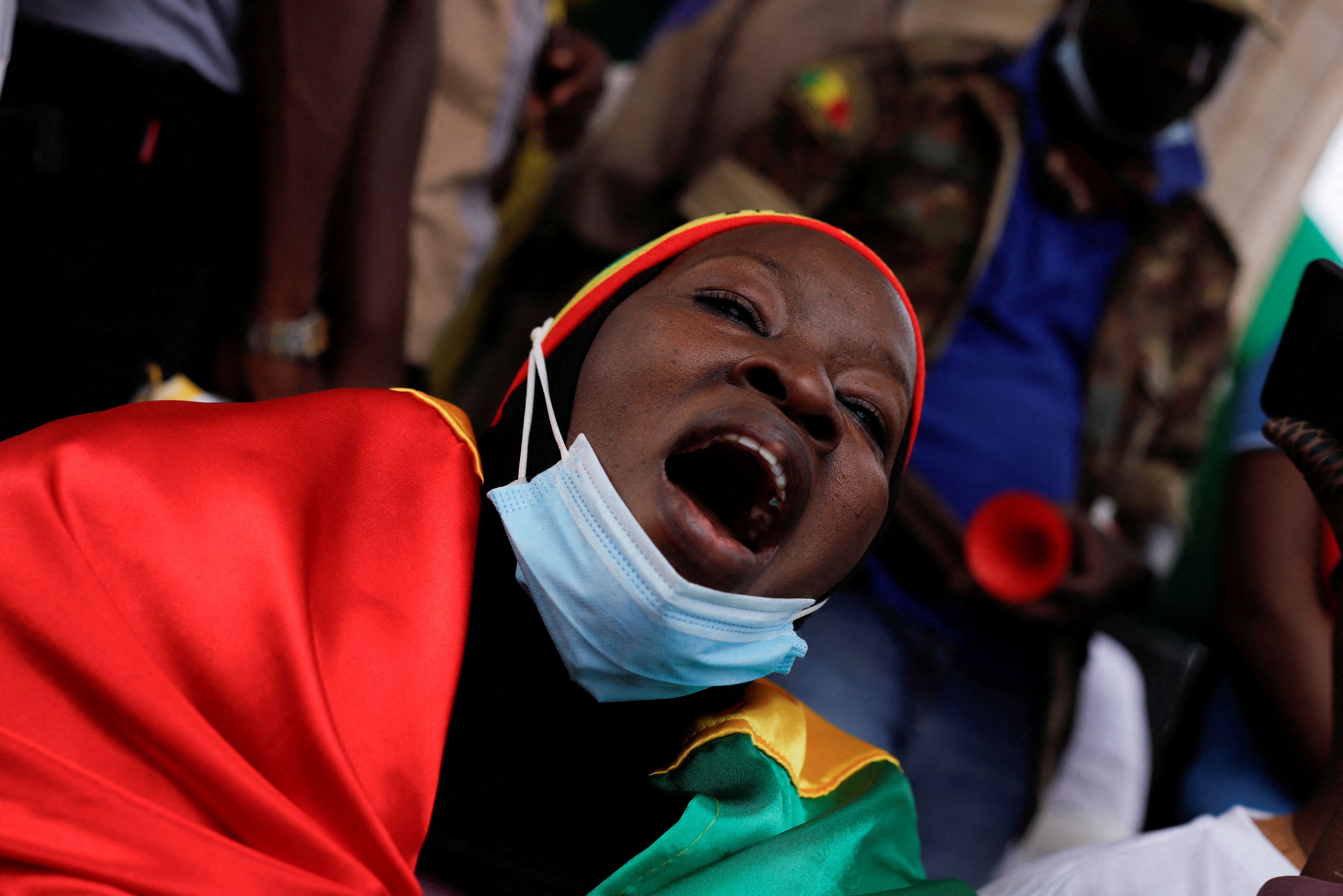 A woman wearing Mali's flag colour, shouts as she participates in a demonstration called by Mali's transitional government after ECOWAS (Economic Community of West African States) imposed sanctions in Bamako, Mali, January 14,