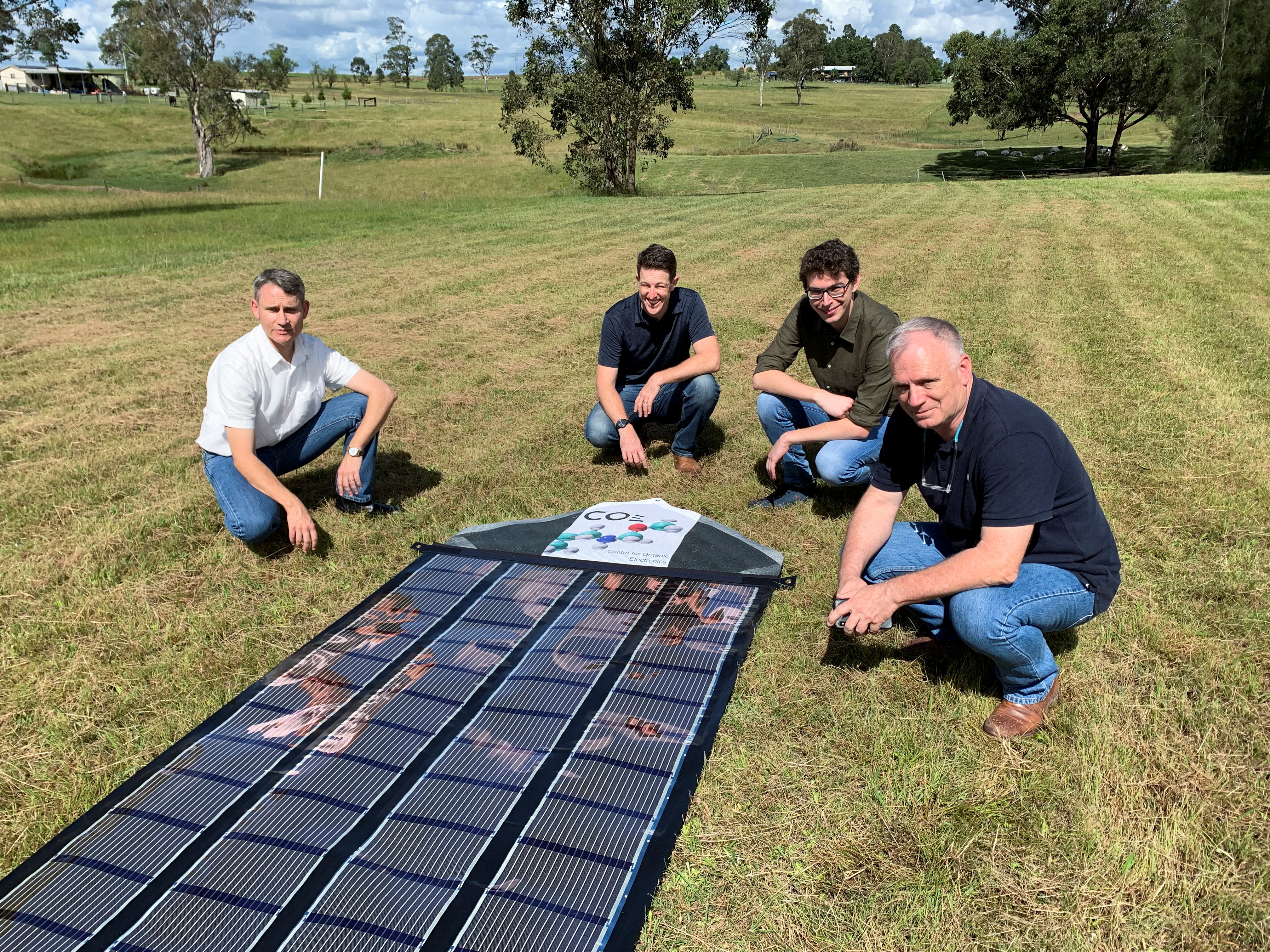 Charge Around Australia project lead and inventor of 'printed solar' panels Paul Dastoor and team members next to a printed solar panel, in Gosforth