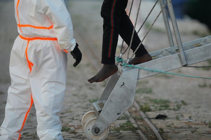 A migrant leaves a rescue boat upon arrival at the port of Malaga