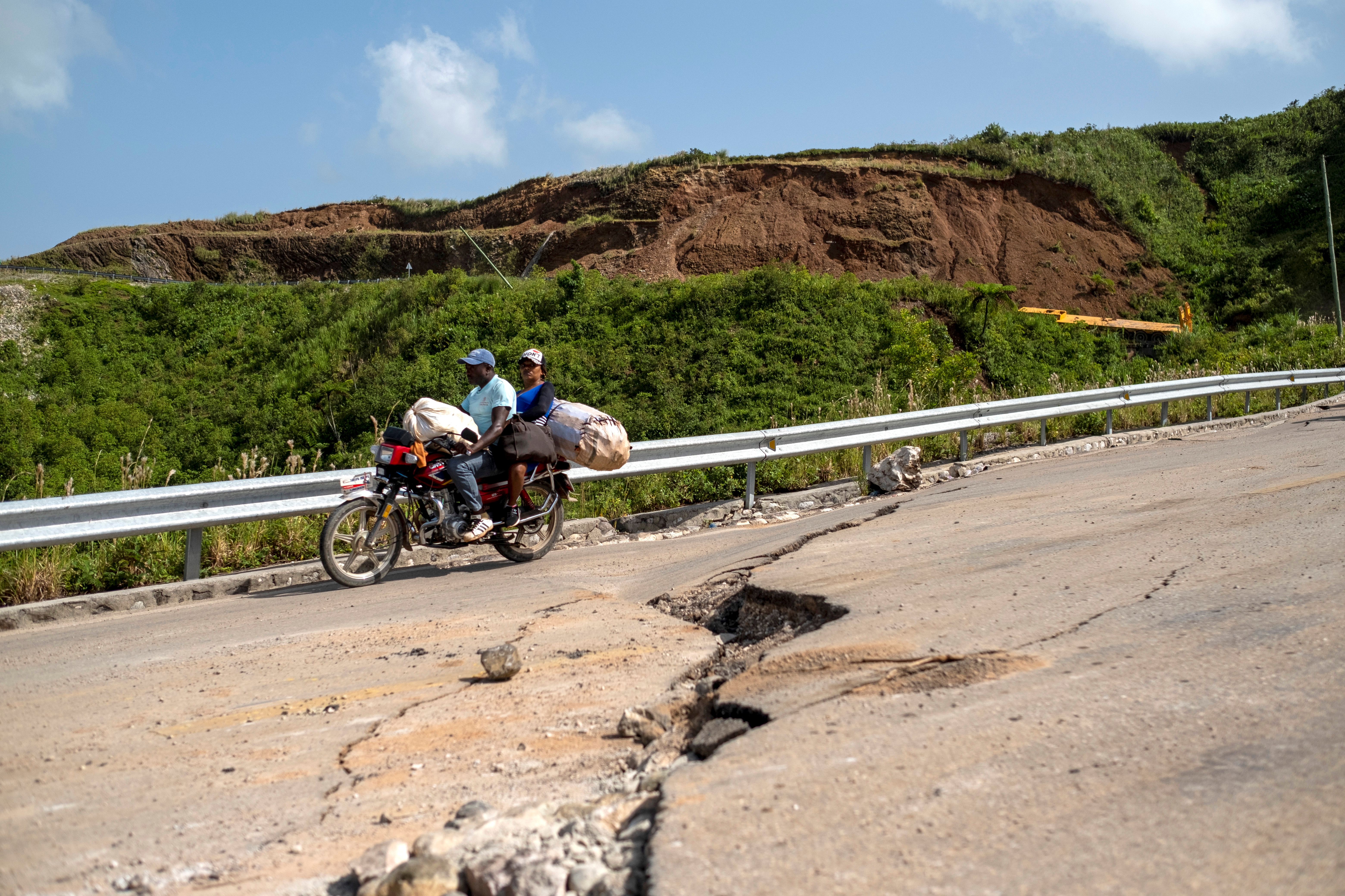 A motorcycle drives on a road with cracks caused by a 7.2 magnitude quake in Marceline, Haiti August 22, 2021. REUTERS/Ricardo Arduengo
