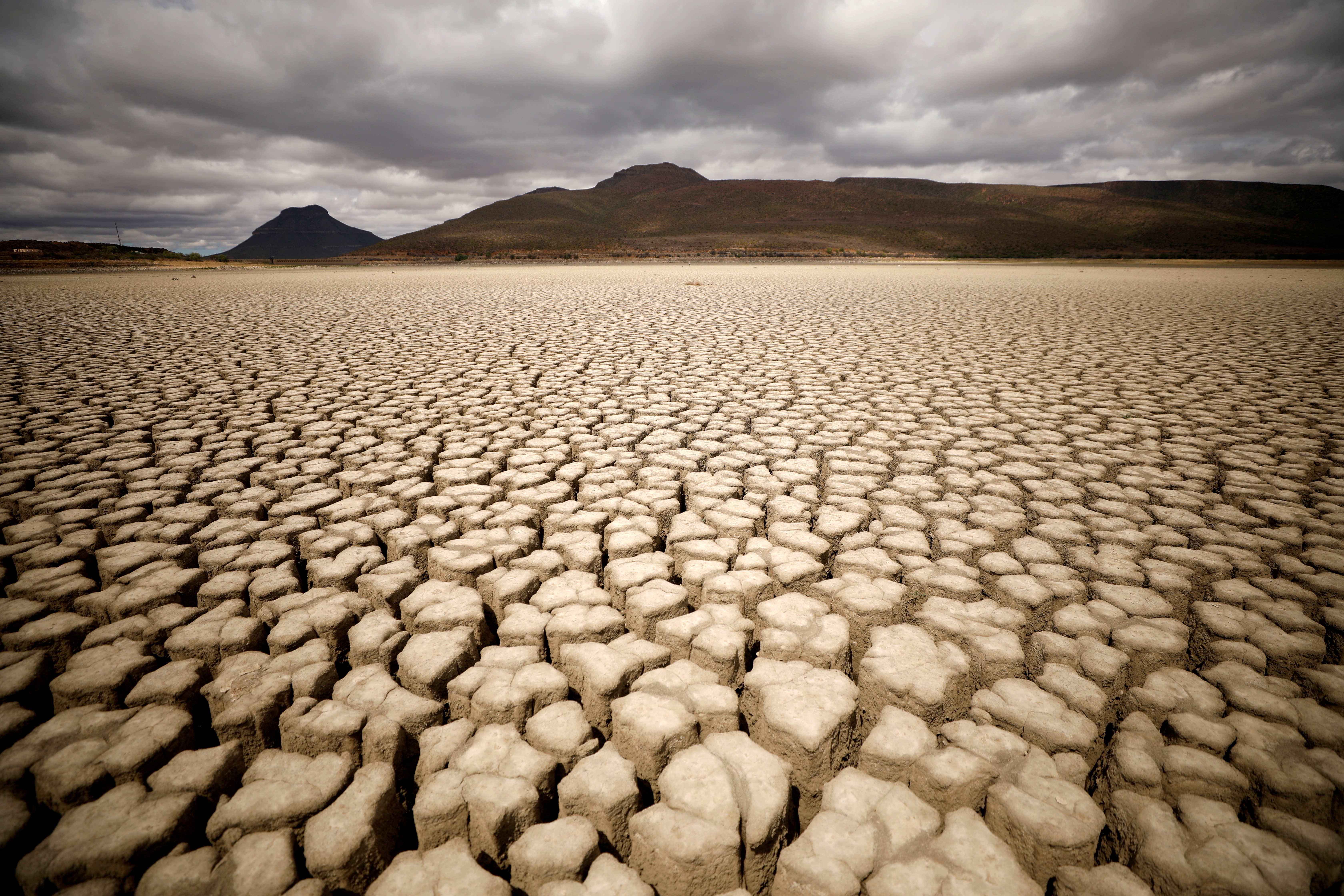 Clouds gather but produce no rain as cracks are seen in the dried up municipal dam in drought-stricken Graaff-Reinet