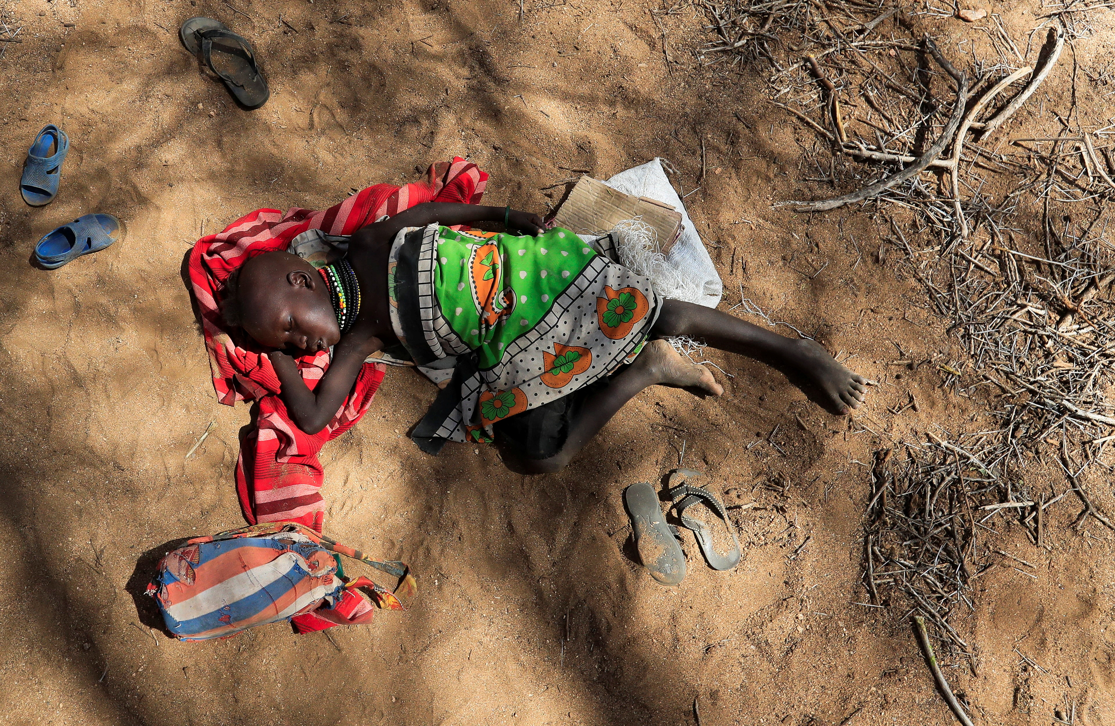 A child from the Turkana pastoralist community affected by the worsening drought due to failed rain seasons, sleeps under a tree as people attend an integrated outreach medical clinic in Kakimat village in Turkana