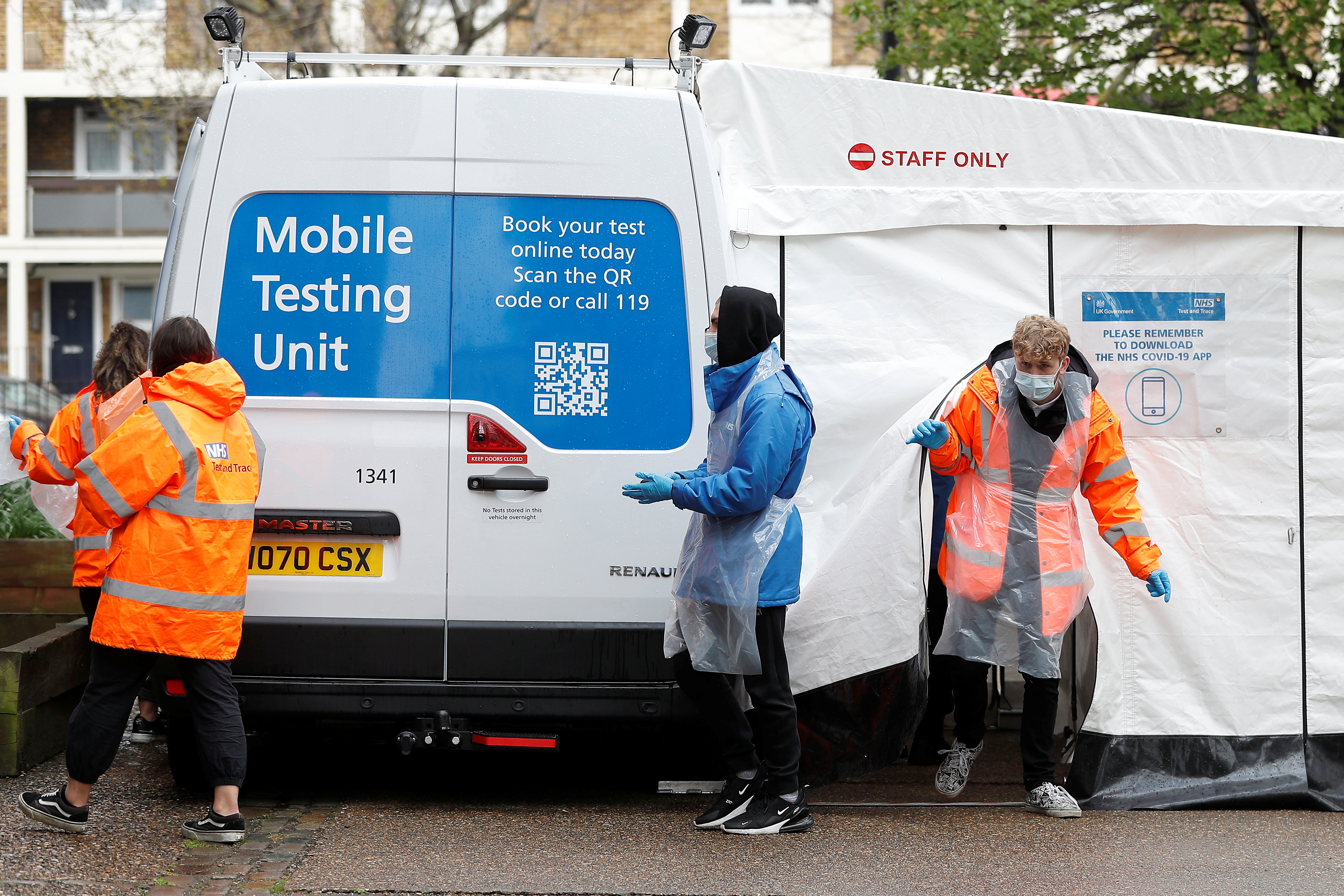 NHS workers are seen next to a coronavirus disease (COVID-19) mobile testing unit in Tower Hamlets, London