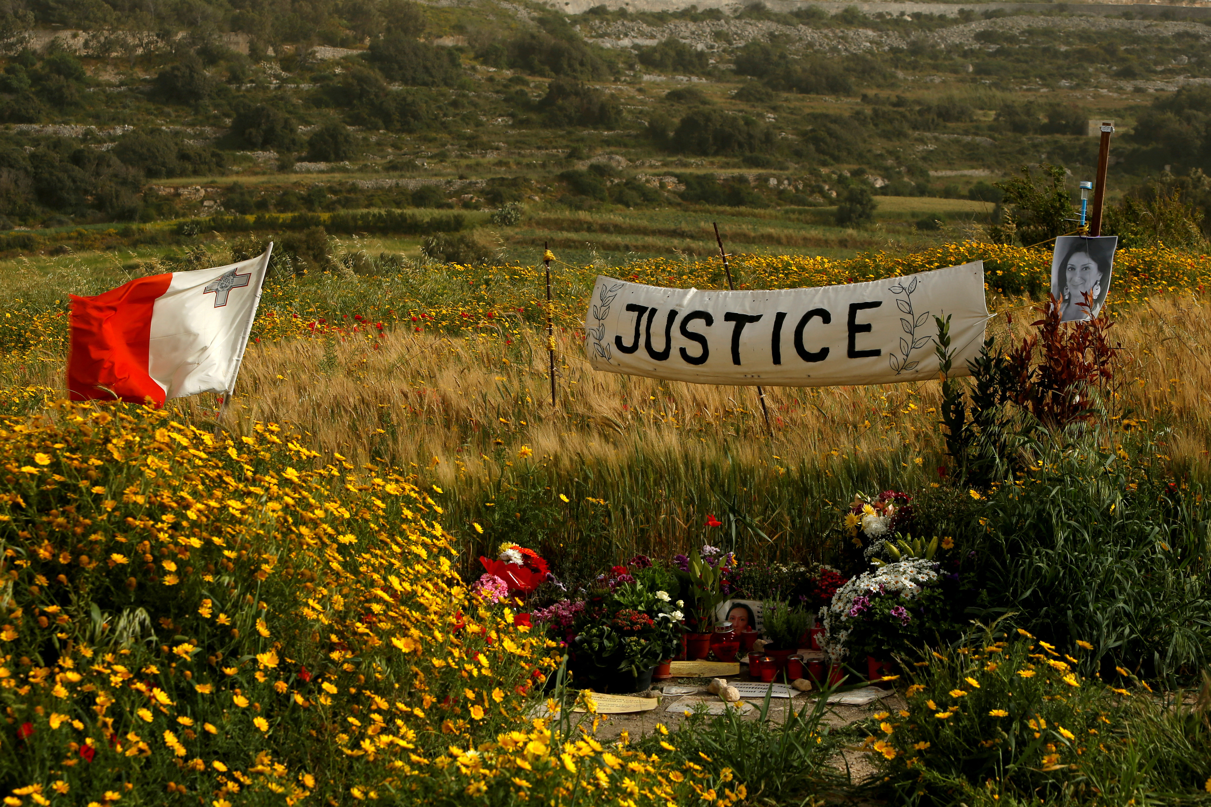 A banner calling for justice is seen next to a photo of assassinated anti-corruption journalist Daphne Caruana Galizia at the bomb site, as Maltese prepare to mark six months since her murder, in Bidnija