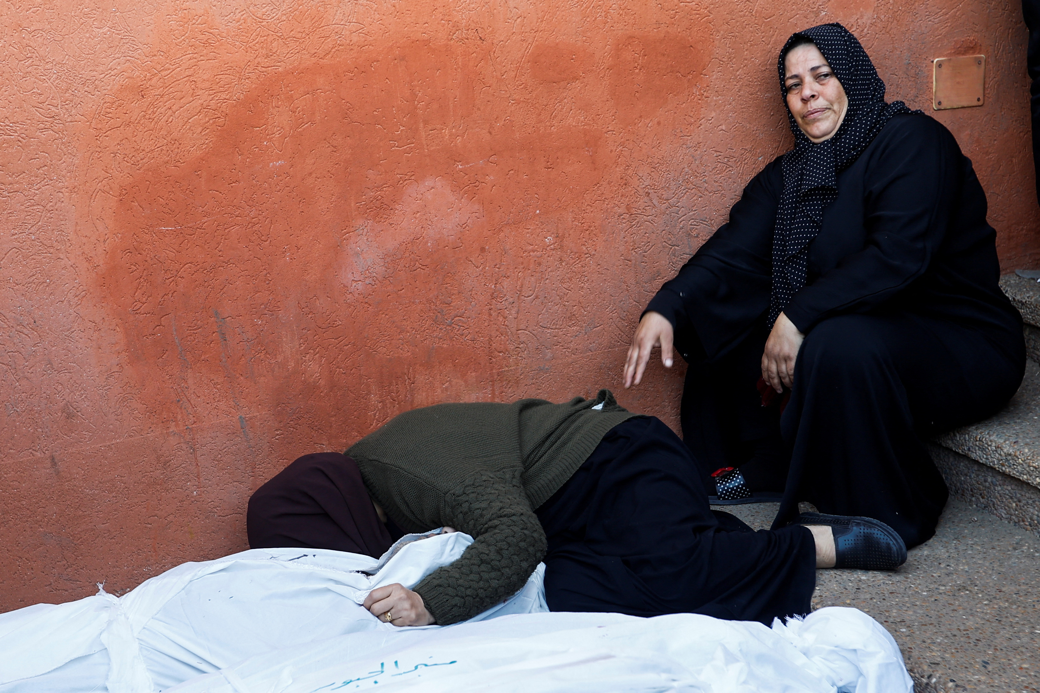 La gente llora junto a los cuerpos de los palestinos muertos en los ataques israelíes, durante su funeral en el Hospital Nasser de Khan Yunis.