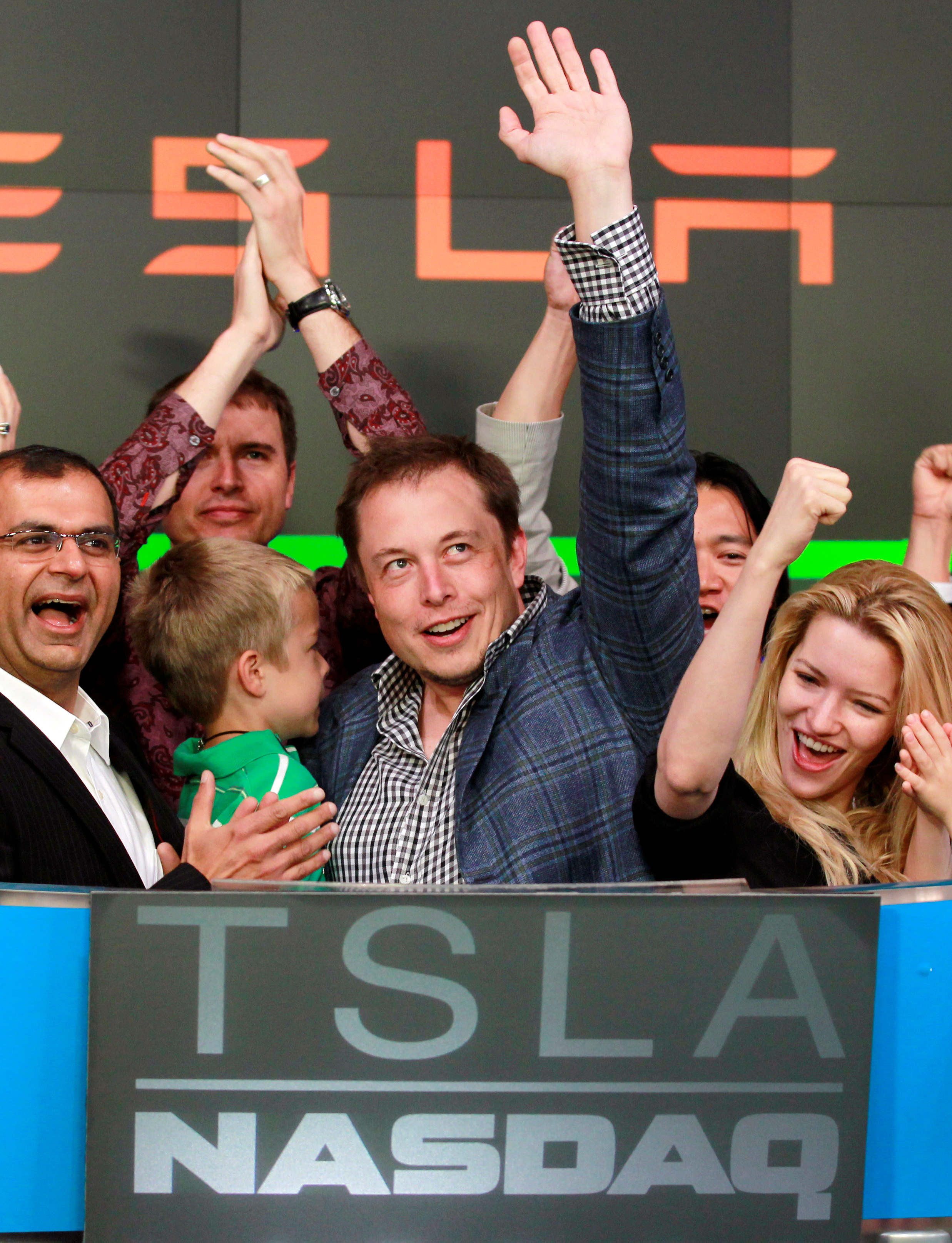 CEO of Tesla Motors Elon Musk waves after ringing the opening bell at the NASDAQ market in celebration of his company's initial public offering in New York
