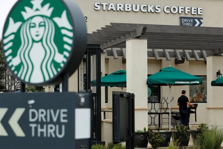 A worker puts away patio furniture at a Starbucks Corp drive-through location closes down this afternoon for anti-bias training as the coffee chain closed all 8,000 of their company-owned cafes in the U.S. including this location in Oceanside, California