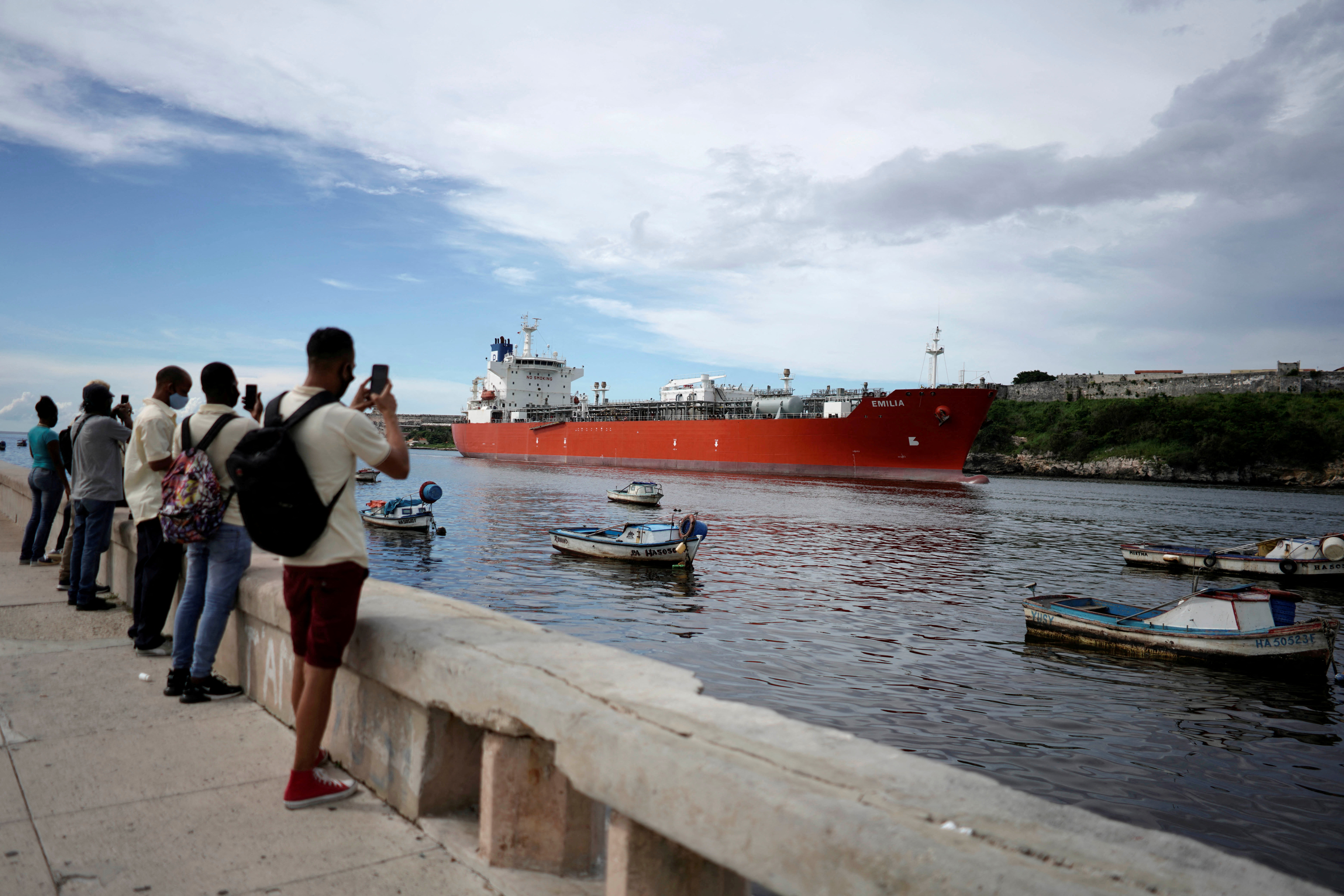 People take pictures of a tanker entering Havana's bay in Cuba