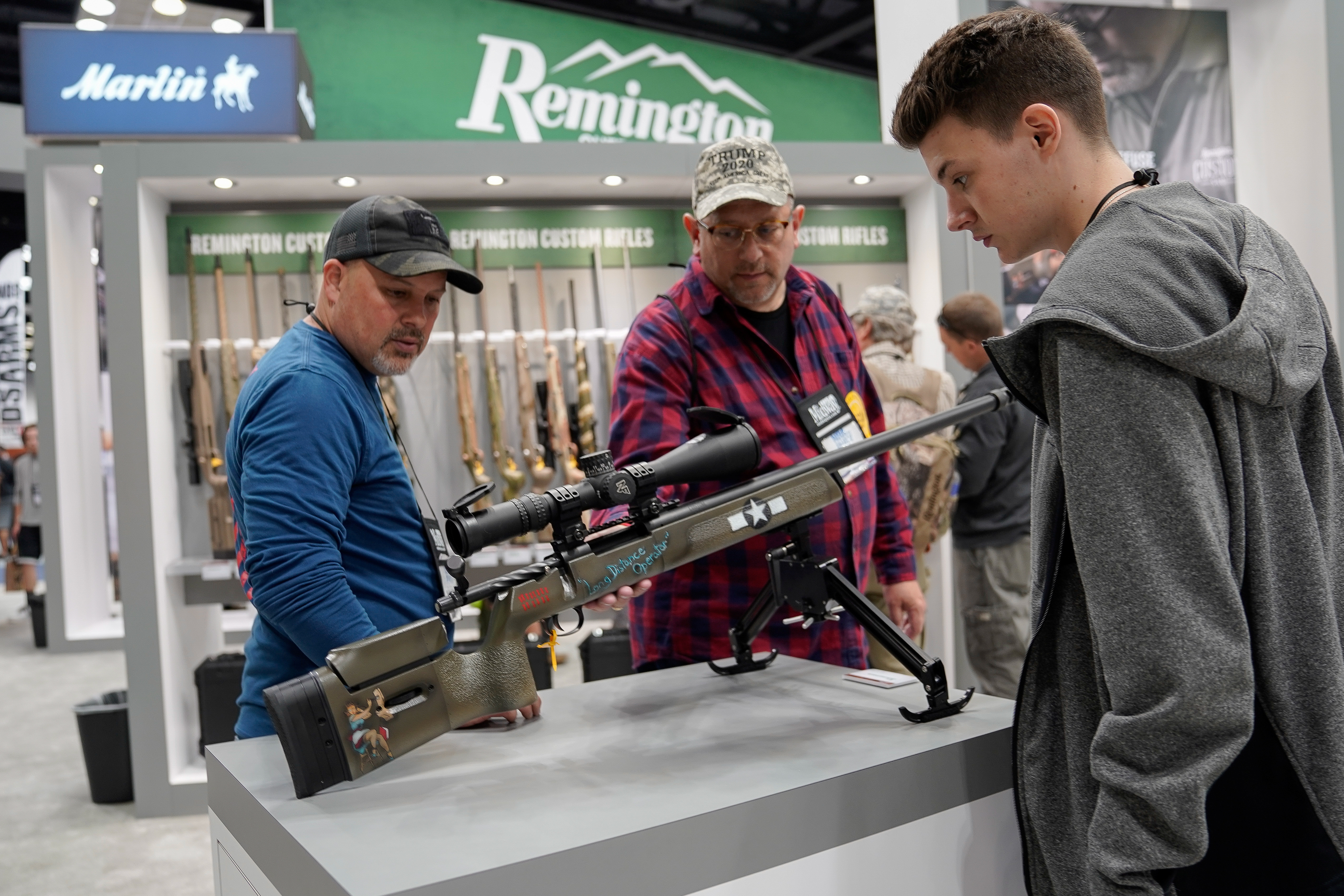 Attendees examine a Remington rifle at the National Rifle Association's (NRA) annual meeting, in Indianapolis, Indiana