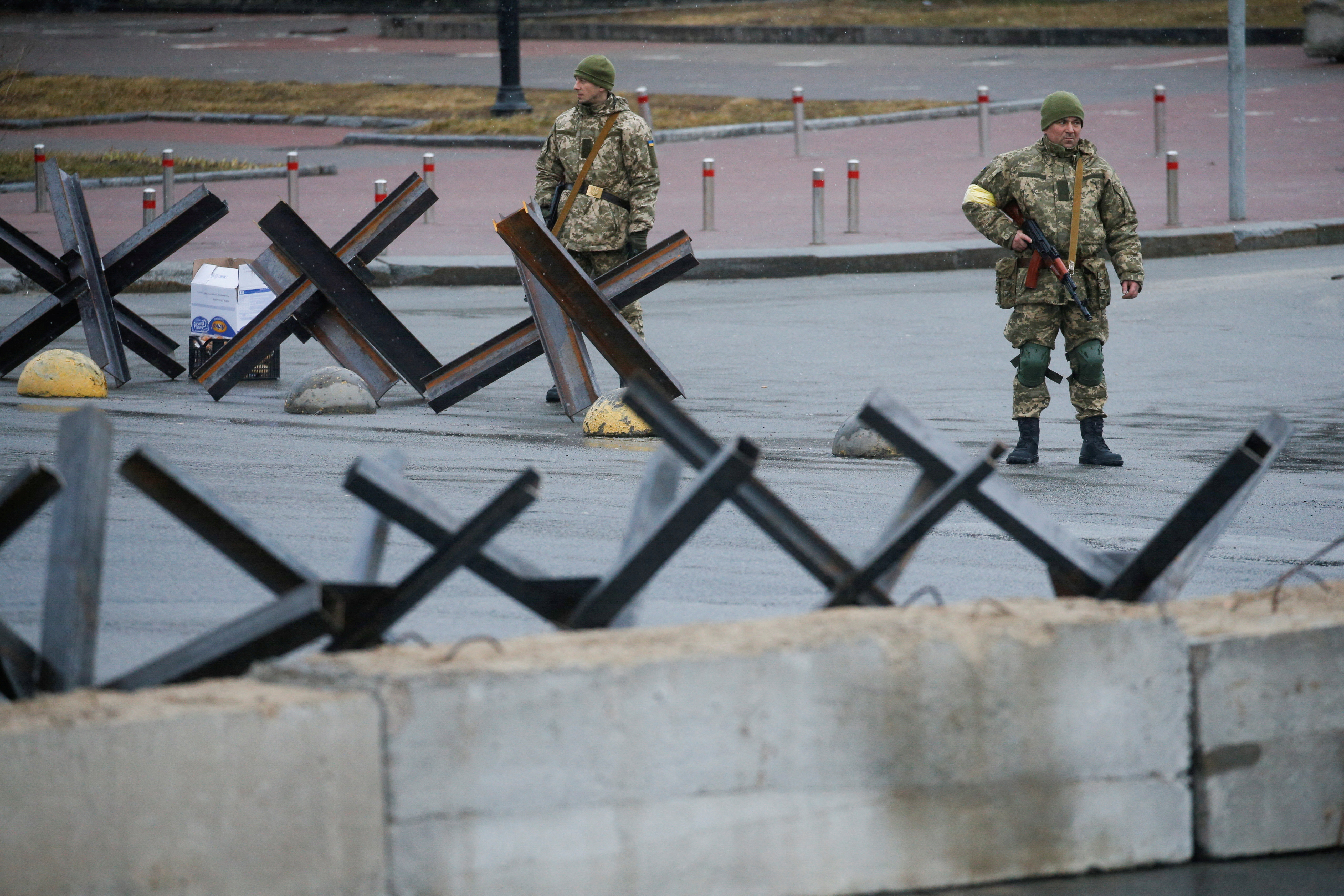 Members of the Territorial Defence Force stand guard at a check point in central Kyiv