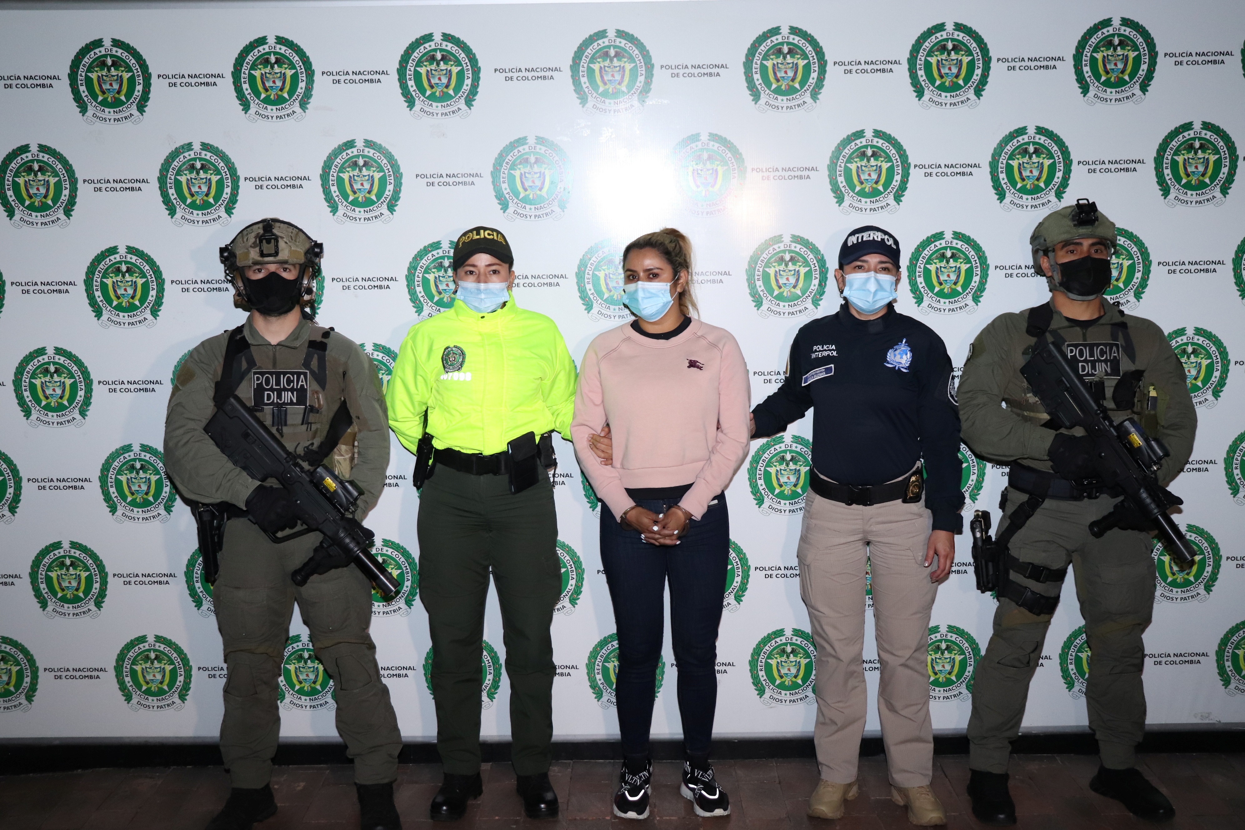 Colombian National Police officers pose for a photo with Nini Johana Usuga, alias 'La Negra', sister of 'Otoniel', top leader of the organized armed group Clan del Golfo, after her arrest in Sabaneta, Colombia March 18, 2021. Colombian National Police/Handout via REUTERS 