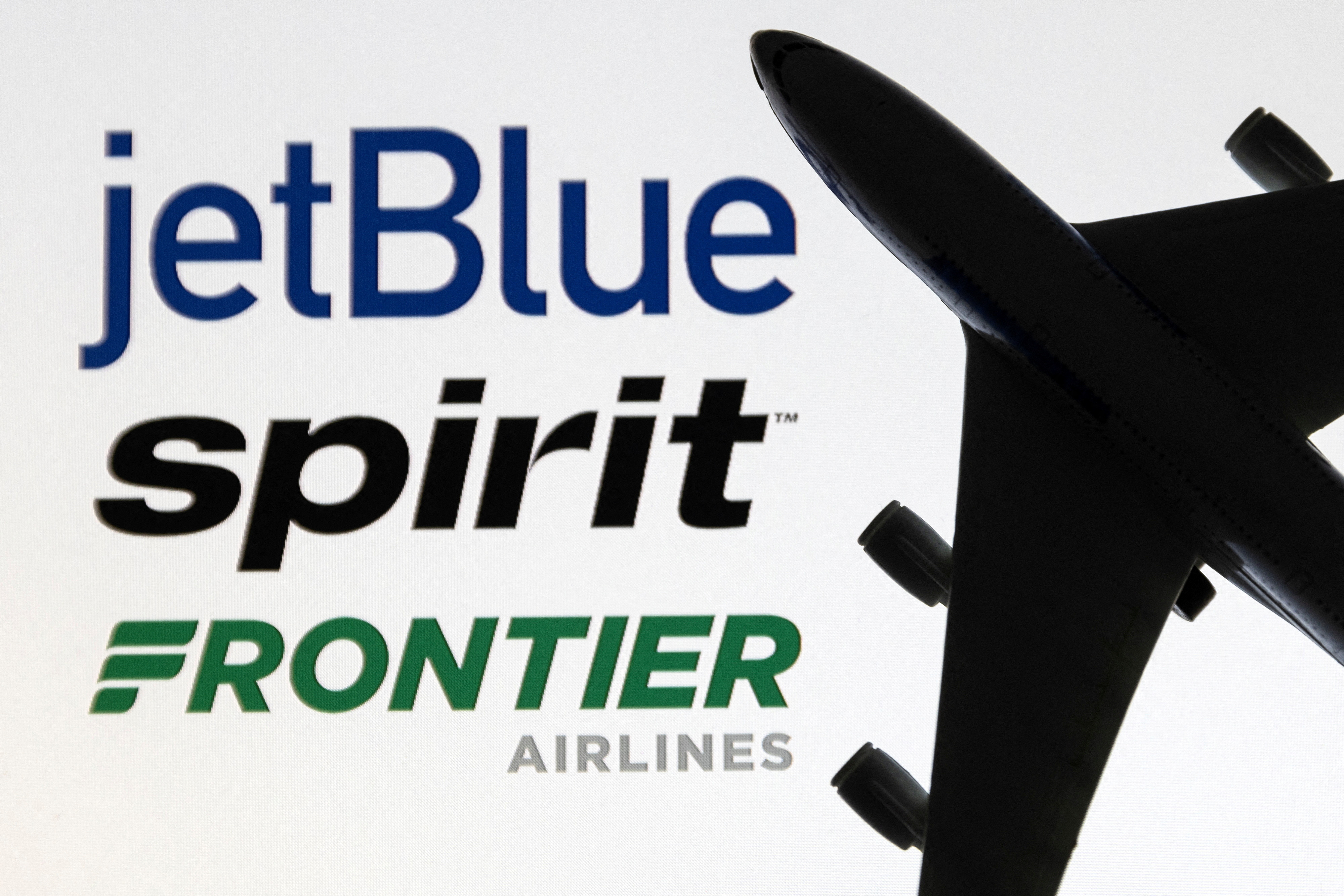 Illustration shows JetBlue, Spirit and Frontier Airlines logos