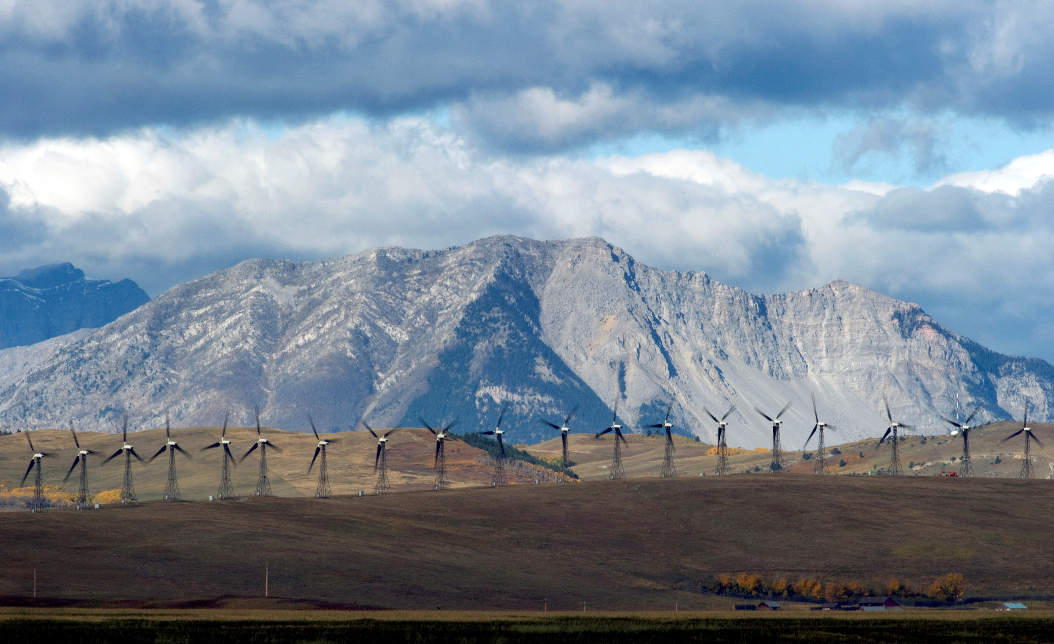 Windmills generate electricity in the windy rolling foothills of the Rocky Mountains near the town of Pincher Creek