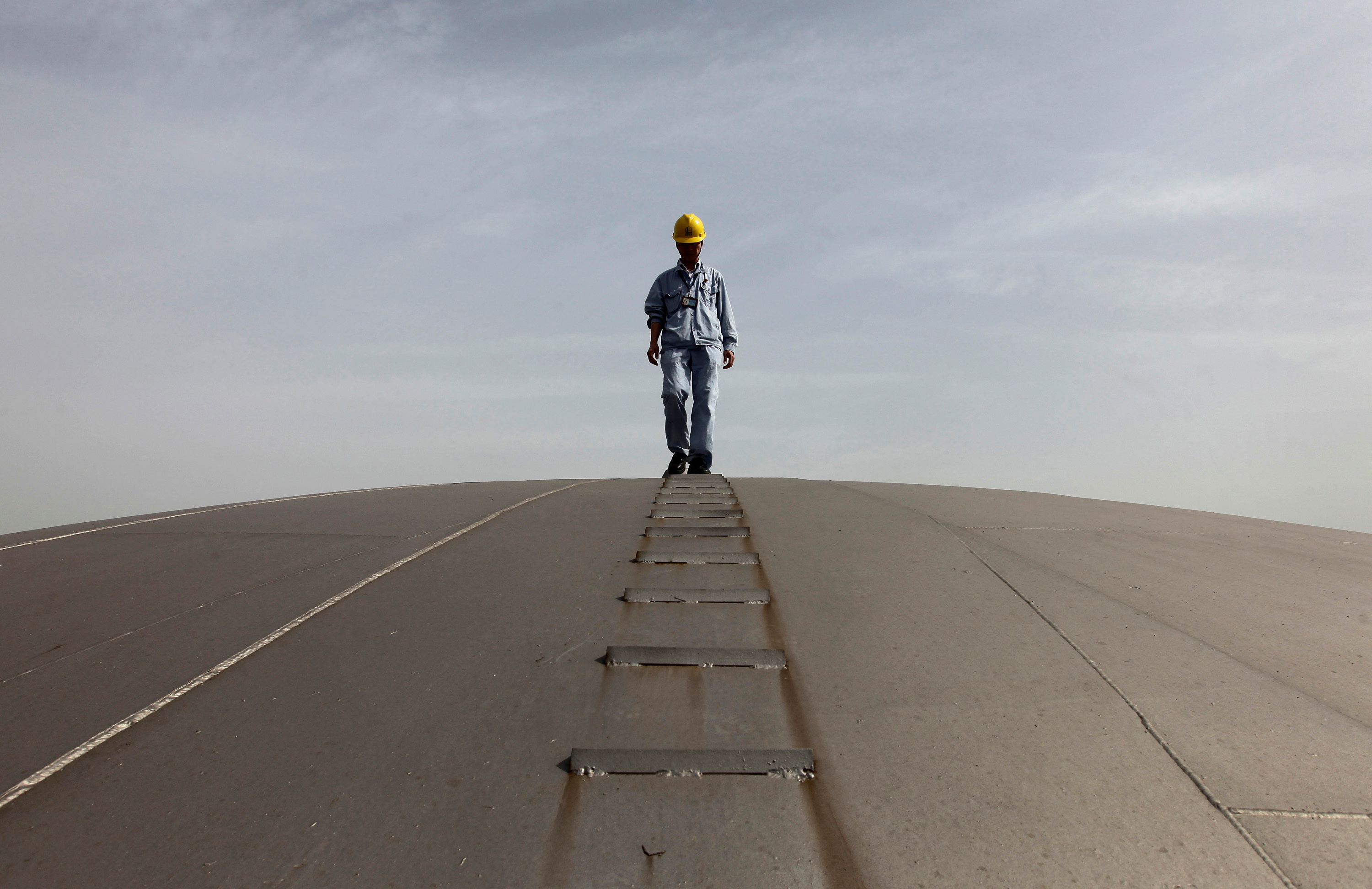 An employee walks on top of an oil tank at a Sinopec refinery in Wuhan, Hubei province
